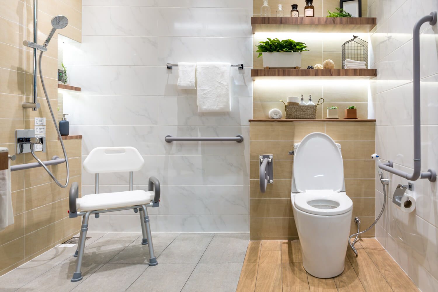Foto eines Badezimmers mit diversen barrierefreien Elementen wie einer ebenerdigen Dusche, Griffen und Handläufen an den Wänden und einem Duschstuhl Foto eines Badezimmers mit diversen barrierefreien Elementen wie einer ebenerdigen Dusche, Griffen und Handläufen an den Wänden und einem Duschstuhl