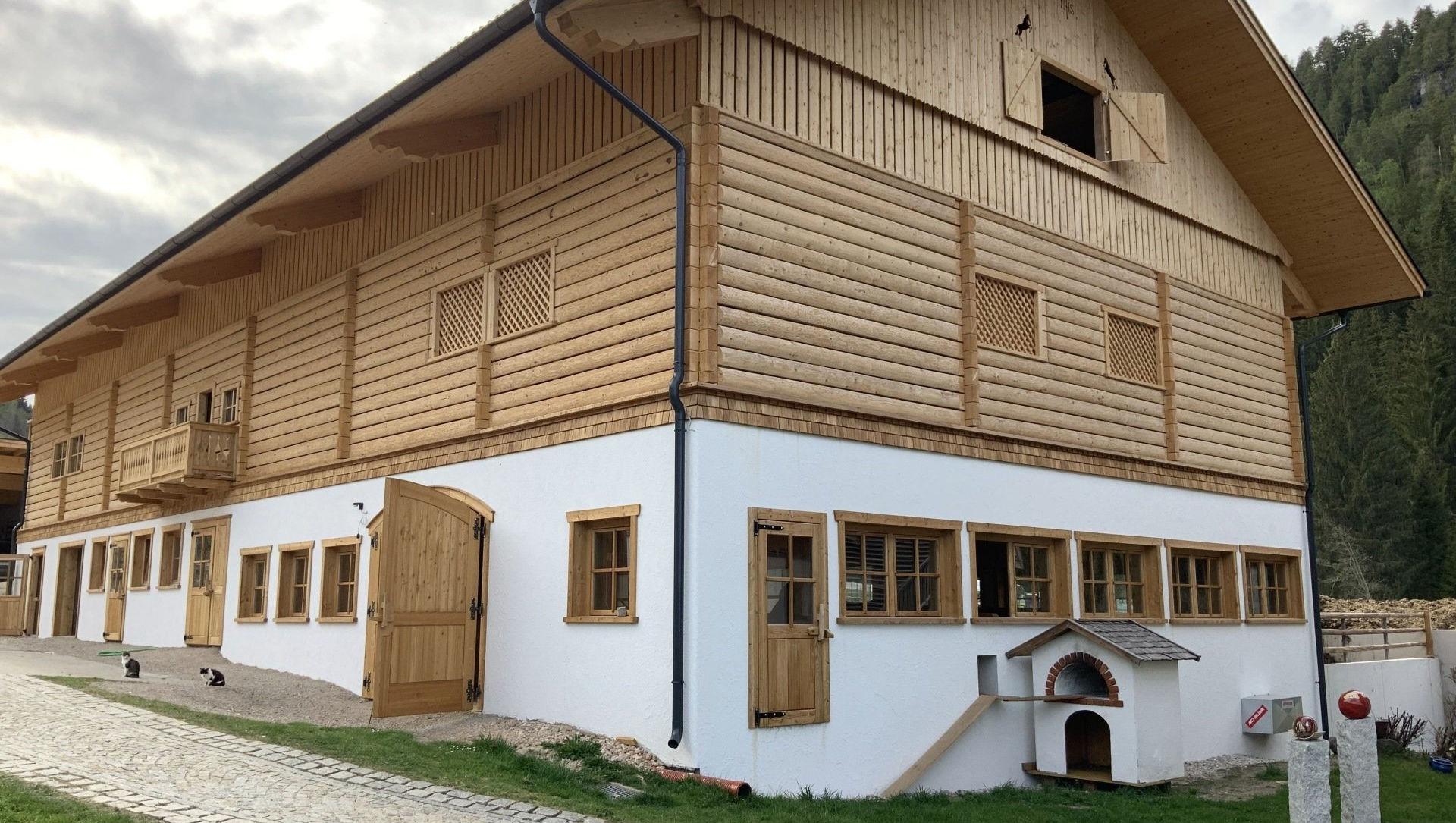 Neubau Rinderlaufstall Mutterkuhstall mit Auslauf Der Stallneubau ist mit viel Holz gebaut und bietet Mutterkühen, Schafen, Pferde und Ziegen viel Platz und passt perfekt zum Urlaub am Bauernhof. Im Obergeschoss ist die Heubergehalle mit einem arbeitssparenden Heukran und einer Heubelüftung ausgestattet. Für das Tierwohl der Pinzgauer Kühe wurde besonders geachtet.
