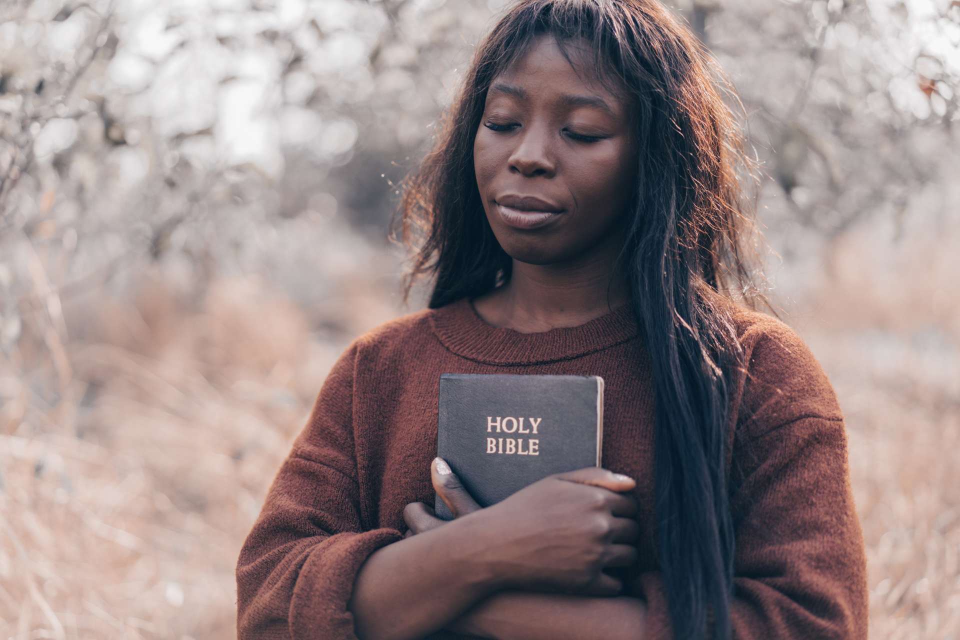 a woman holding a Bible to her chest