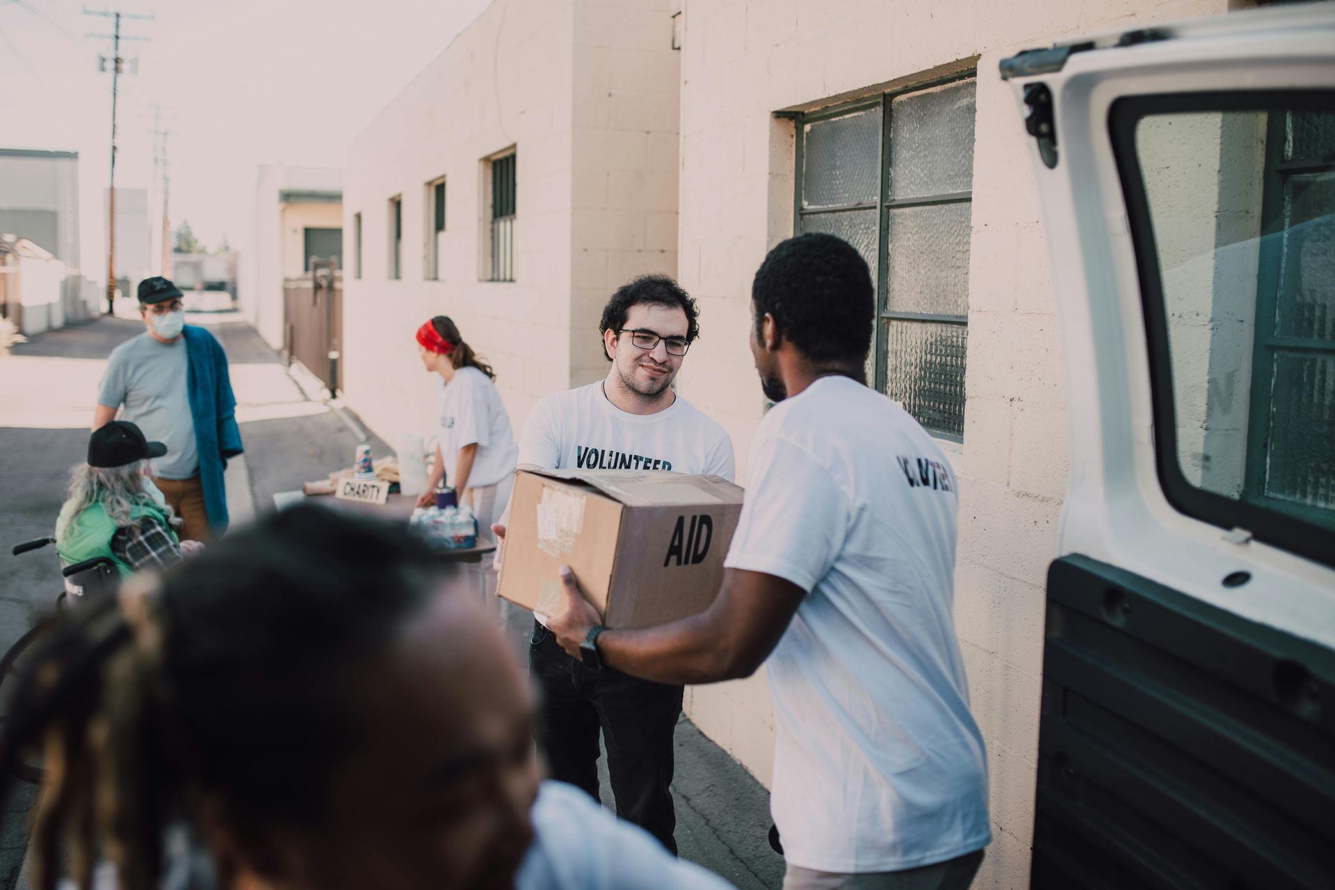 a volunteer in a mask delivering a package to an elderly resident