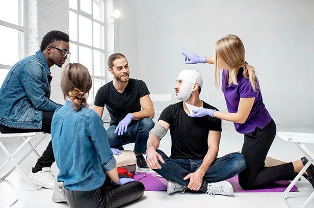 Erste-Hilfe-Kurse Herzdruckmassage vor einer Teilnehmergruppe