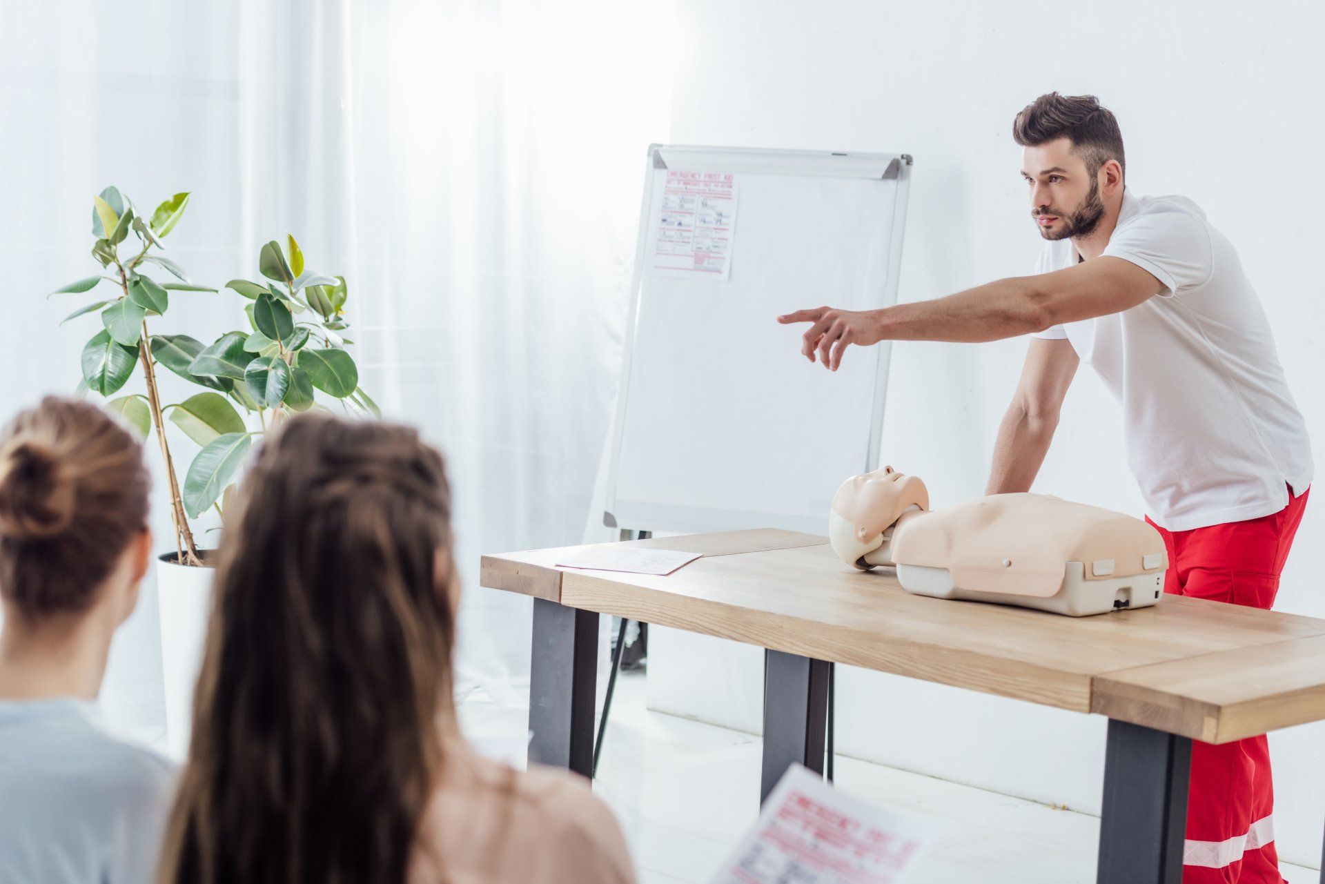 Erste-Hilfe-Ausbilder spricht eine Teilnehmerin an