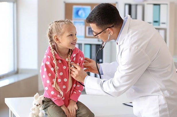 Notfalltraining in der Kinderarztpraxis Kinderarzt hört die Lunge von einem Kind ab