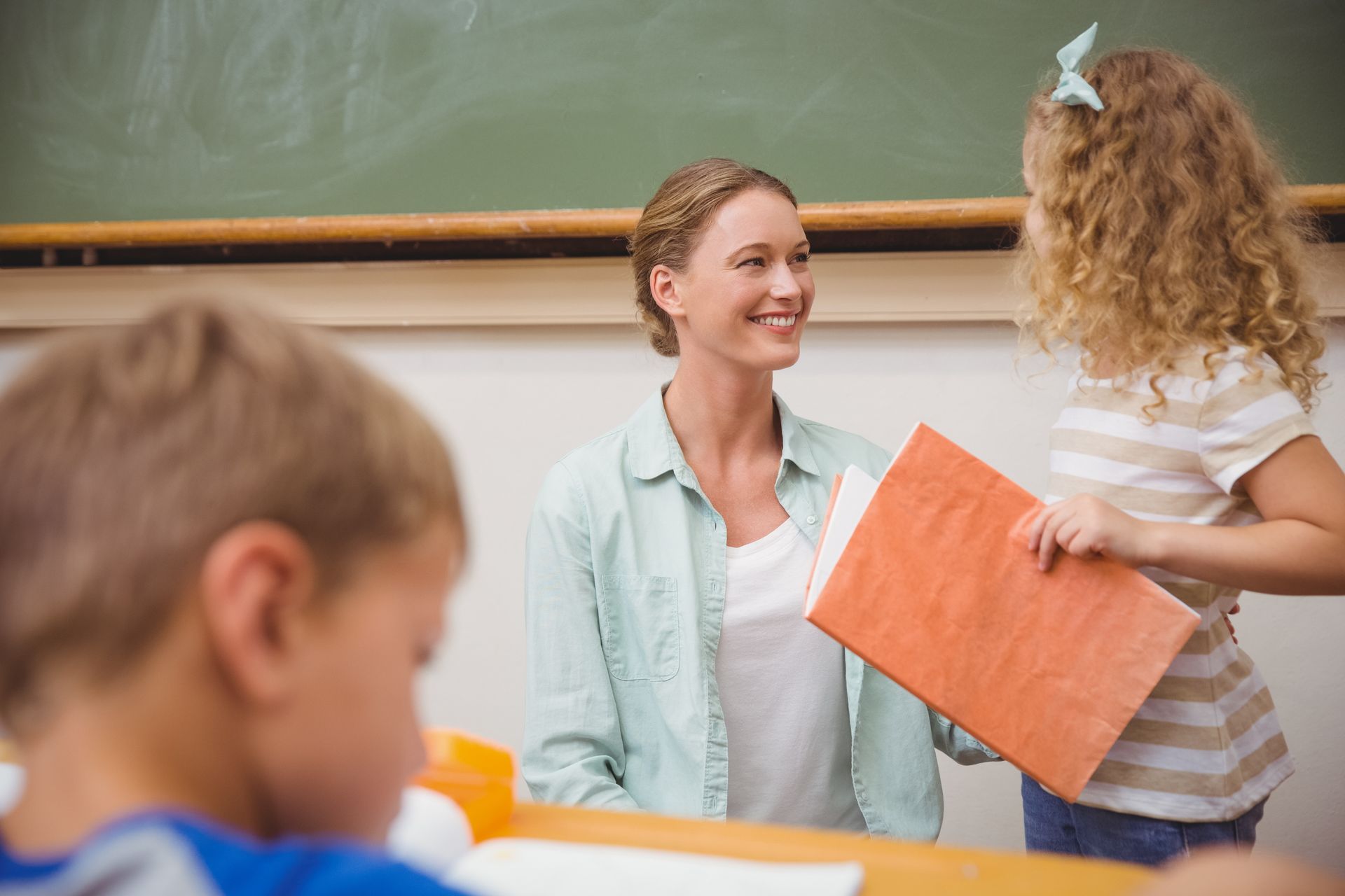 Erste-Hilfe-Schulung in Bildungs- und Betreuungseinrichtungen für Kinder Lehrerin lächelt Kind an