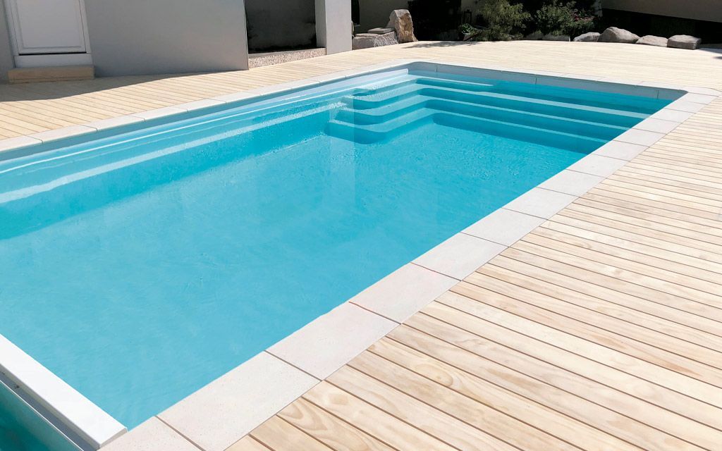 Suelo de madera natural exterior claro en una piscina de casa de lujo en Barcelona