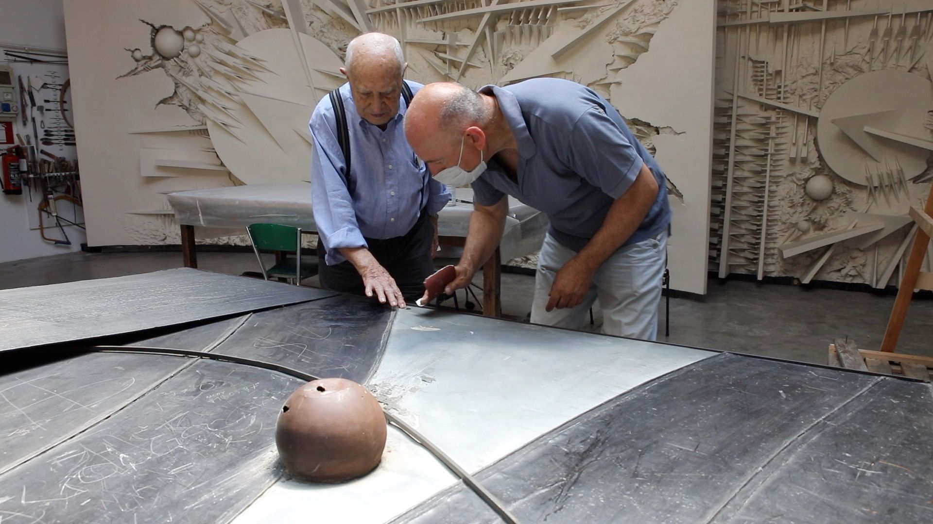 L'artista italiano Arnaldo Pomodoro e il suo assistente Massimo Sassi lavorano all'opera L'inizio del tempo