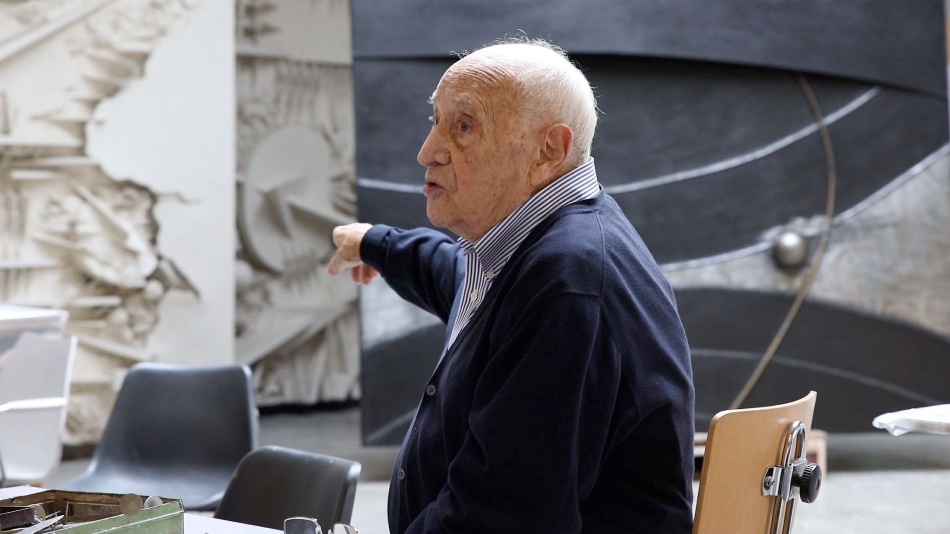 L'artista italiano Arnaldo Pomodoro siede davanti all'opera L'inizio del tempo