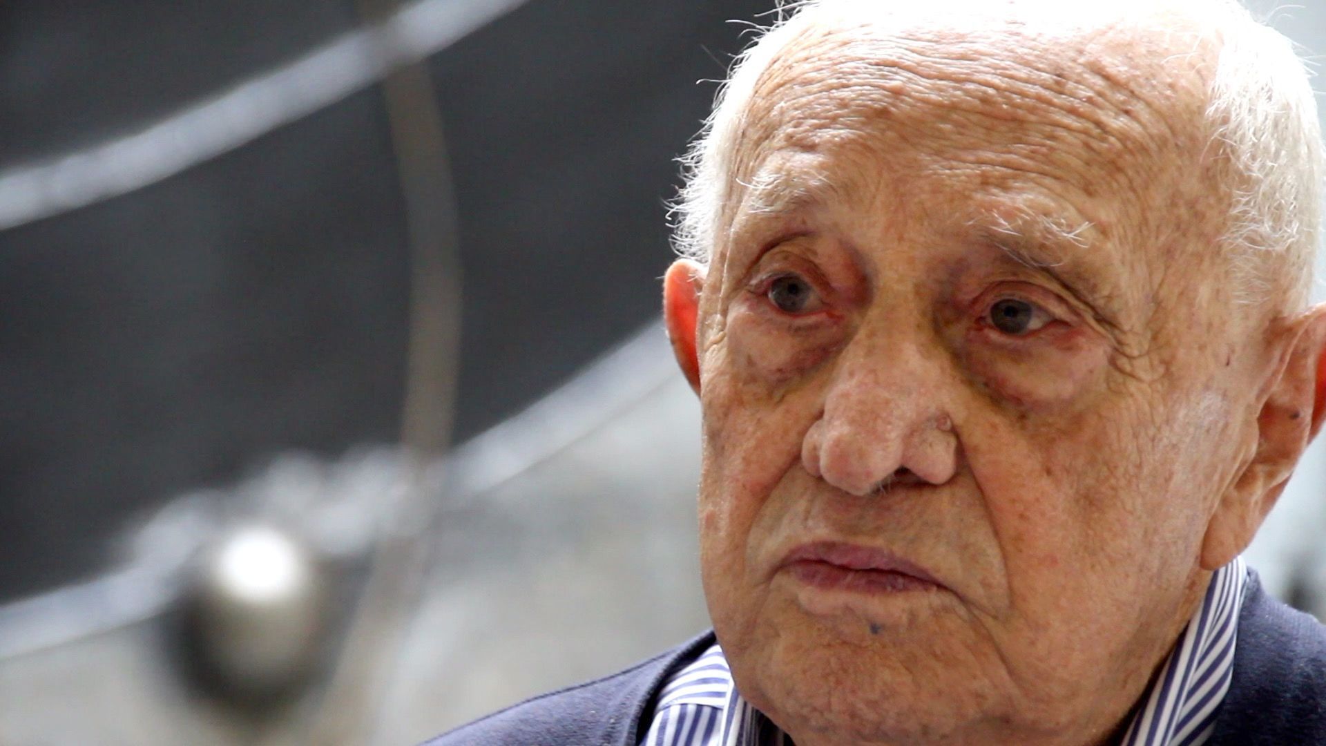 L'artista italiano Arnaldo Pomodoro siede davanti all'opera L'inizio del tempo