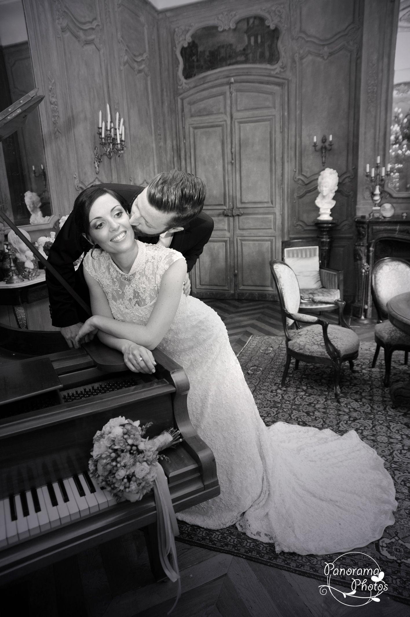 photo de mariage montrant un couple de mariés accoudés à un piano