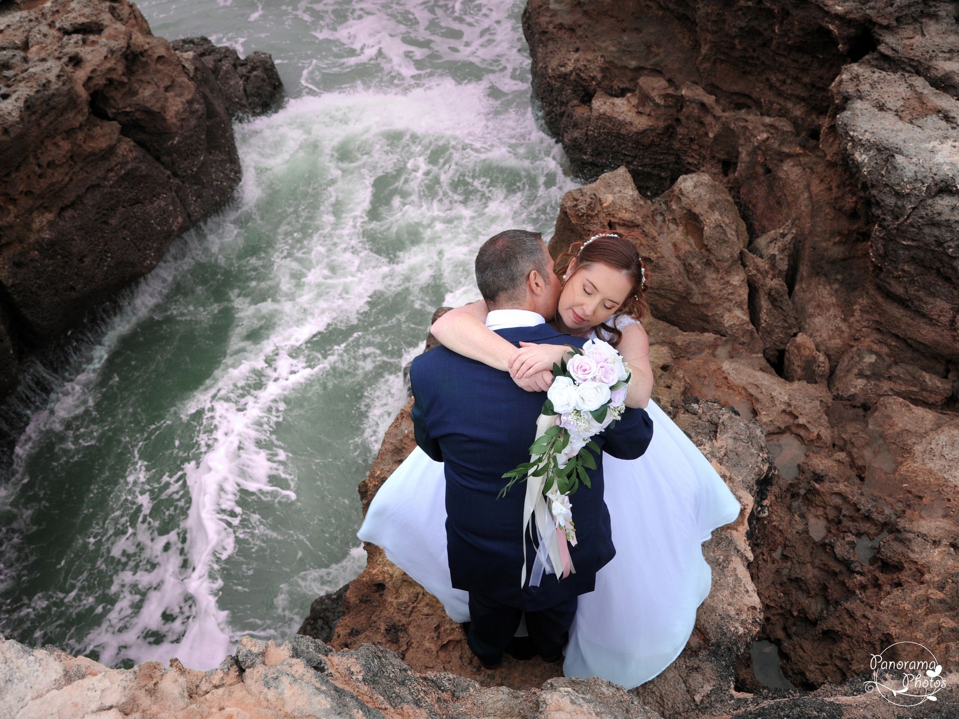 photo de mariage montrant des mariés vue d'en haut au bord de la mer