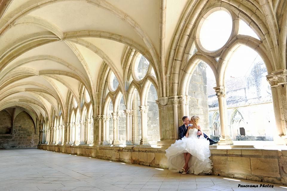 photo de mariage montrant des mariés assis dans le cloitre d'une abbaye