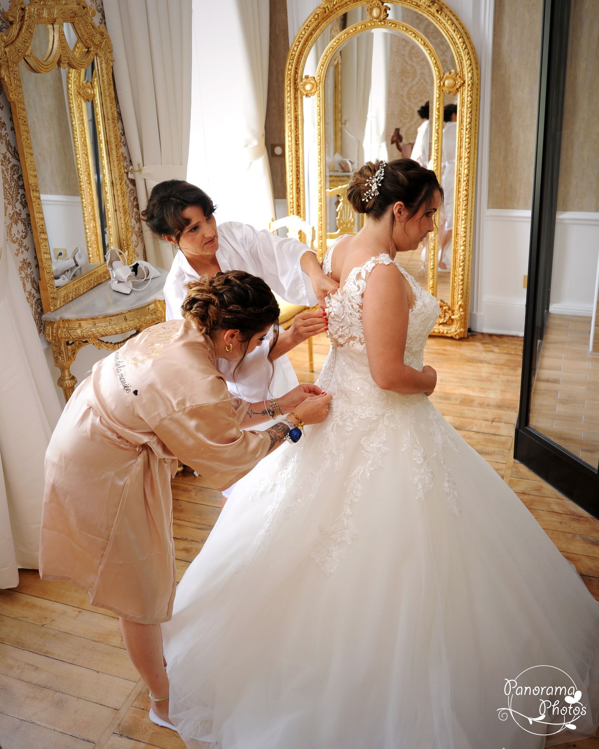 Mariée en train de s'habiller avec ses demoiselles d'honneurs