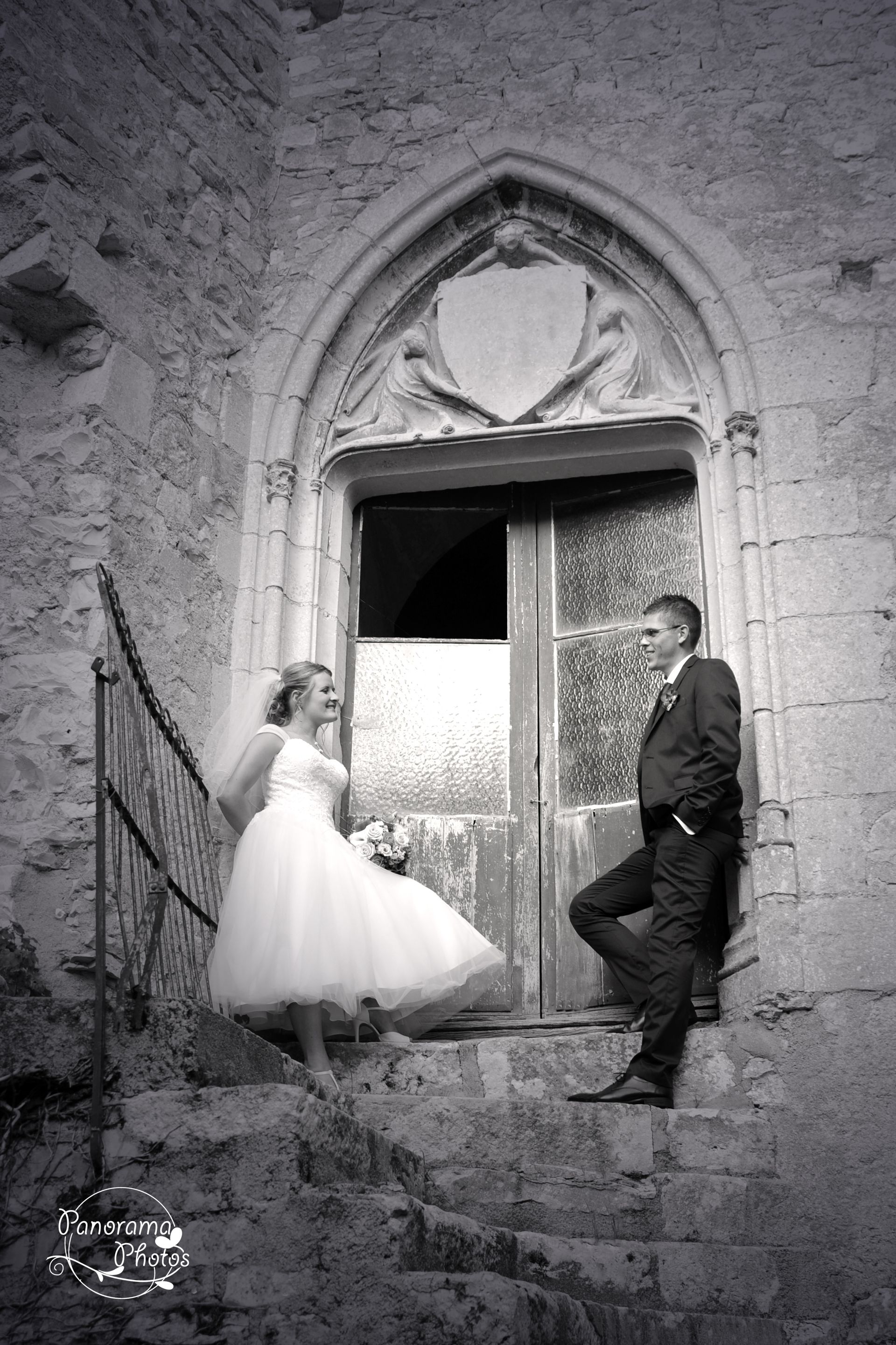 photo de mariage montrant un couple de mariés posant devant une vielle porte