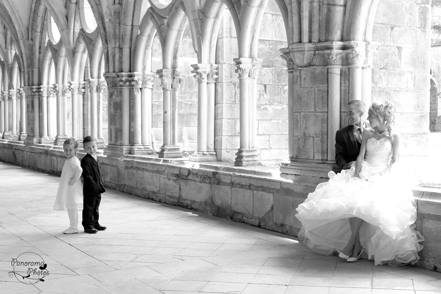 photo de mariage montrant un couple de mariés qui regardent leurs enfants