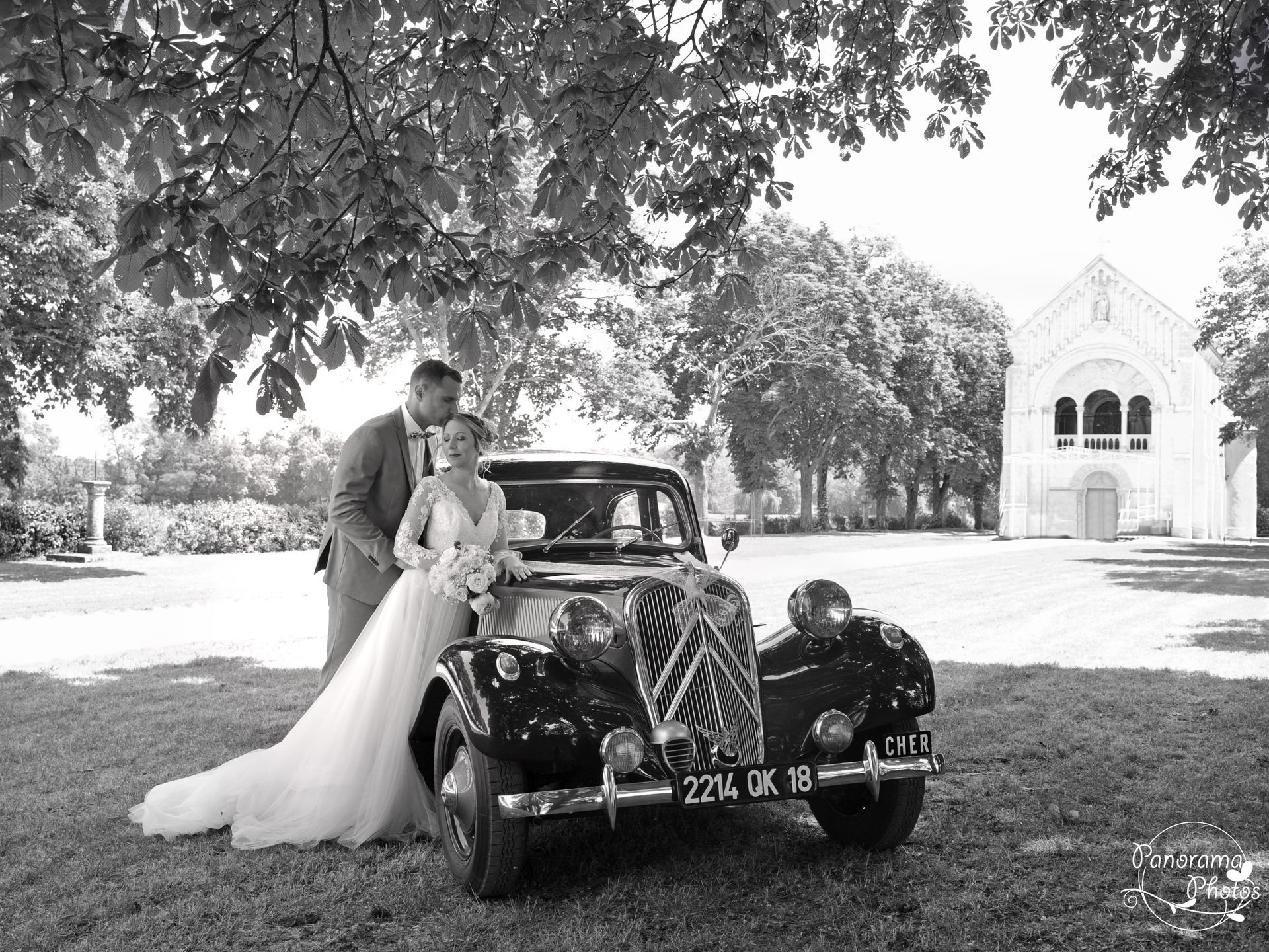 photo de mariage montrant mariés accoudés à une voiture ancienne