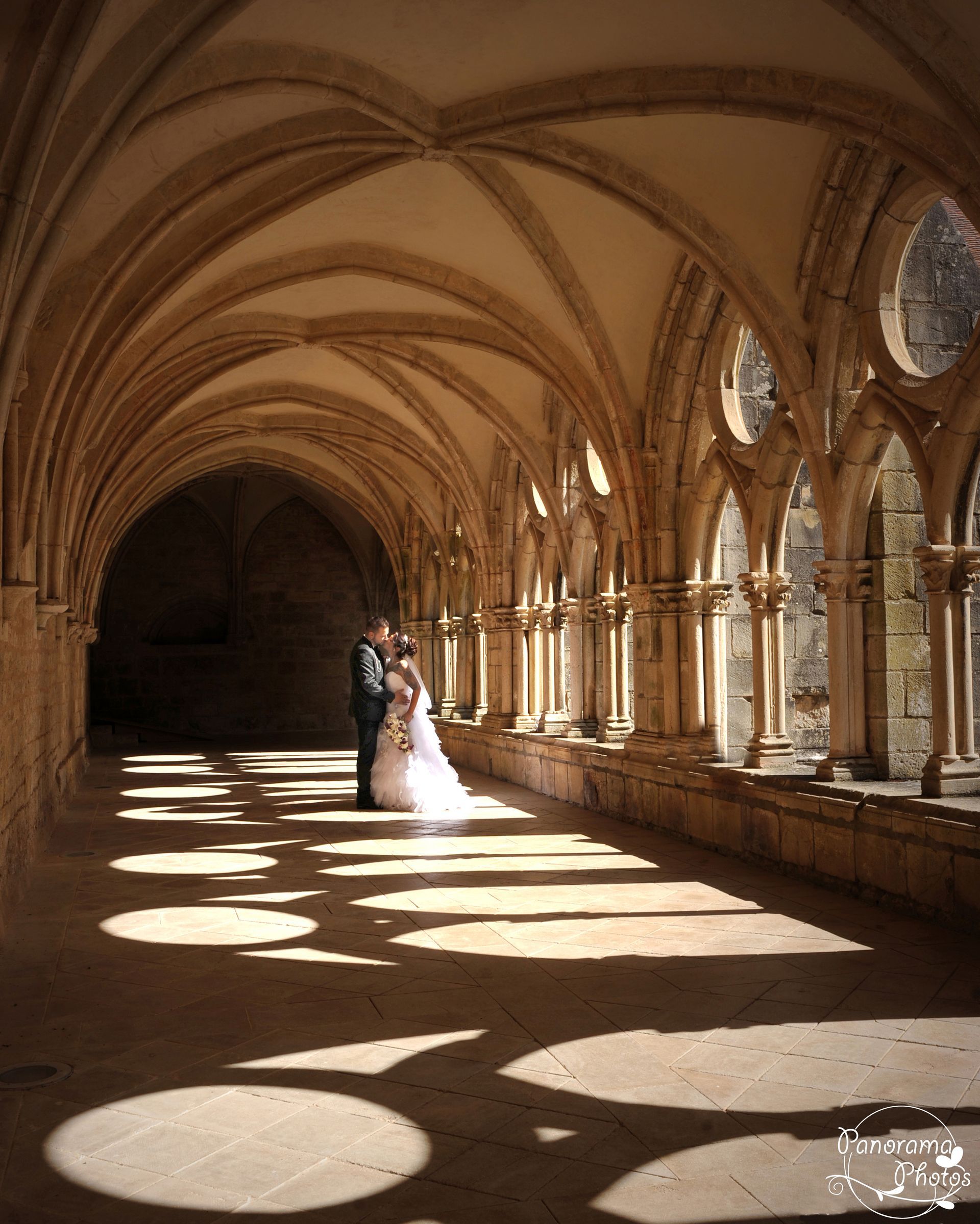 photo de mariage montrant des mariés dans le cloitre d'une abbaye avec jeu d'ombre
