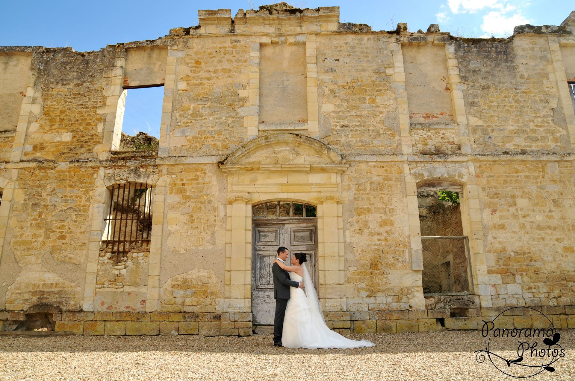 photo de mariage montrant des mariés devant un vieux mur