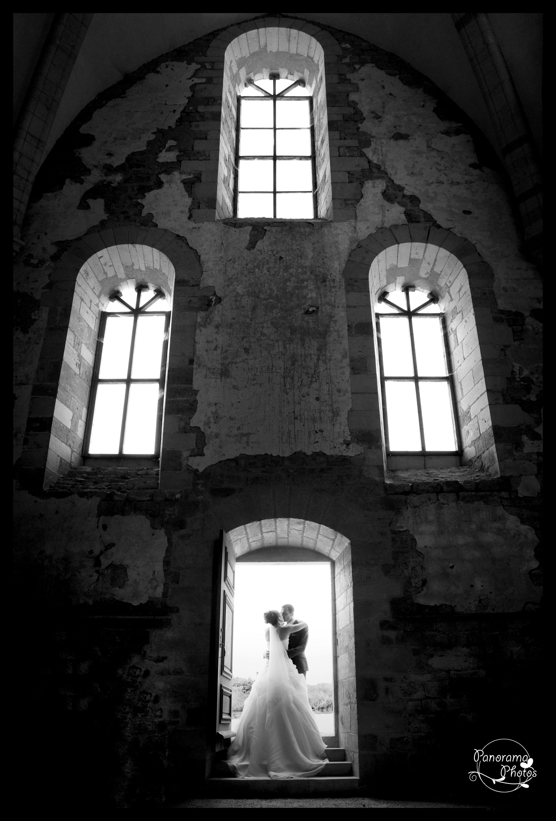 photo de mariage montrant des mariés s'embrassent dans en contre jour