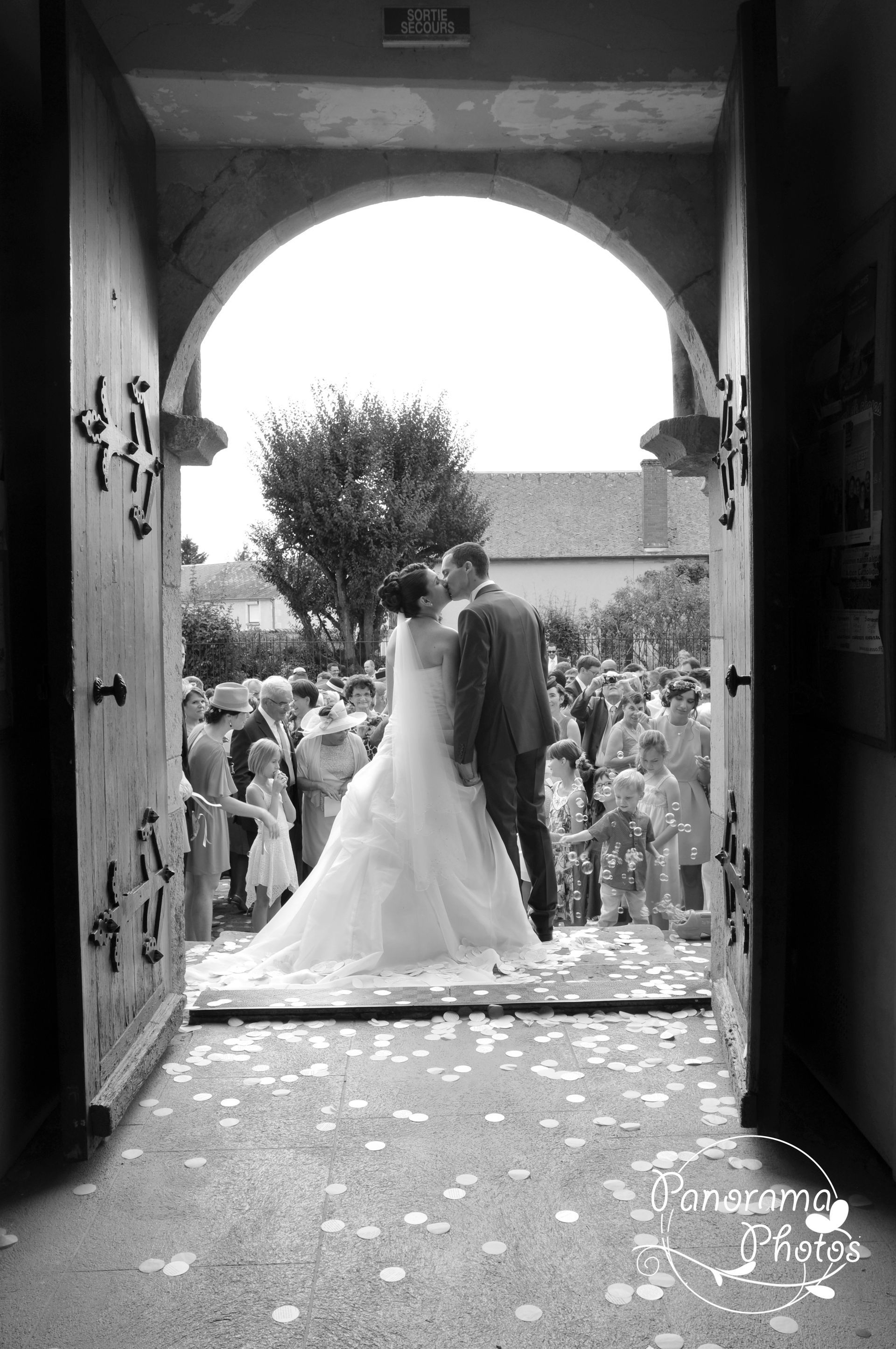 Couple de marié sortant de l'église vue de dos