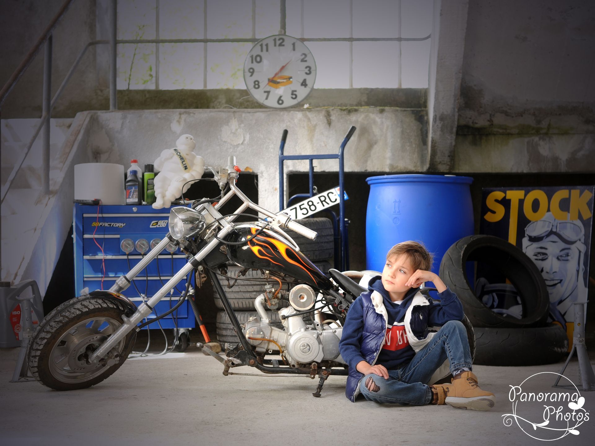 séance photo extérieure portrait garçon assis devant une moto dans une usine désaffectée