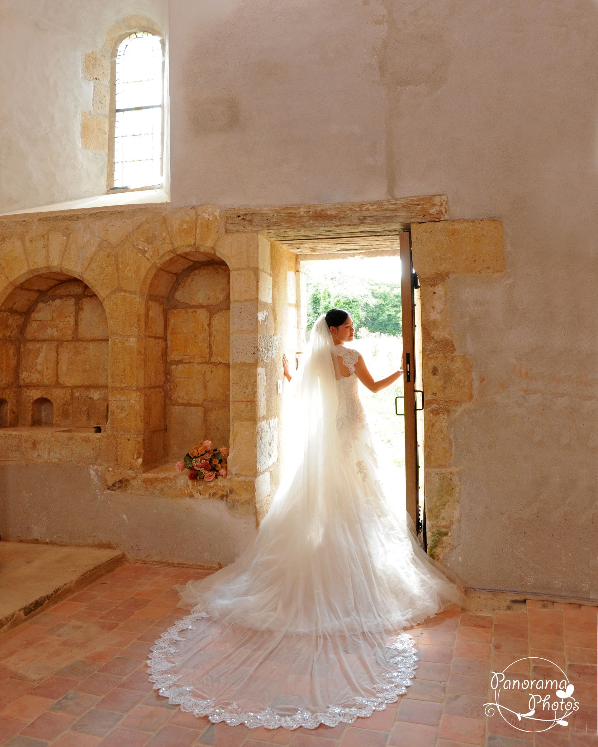 mariée de dos en contre jour dans une porte d'une abbaye