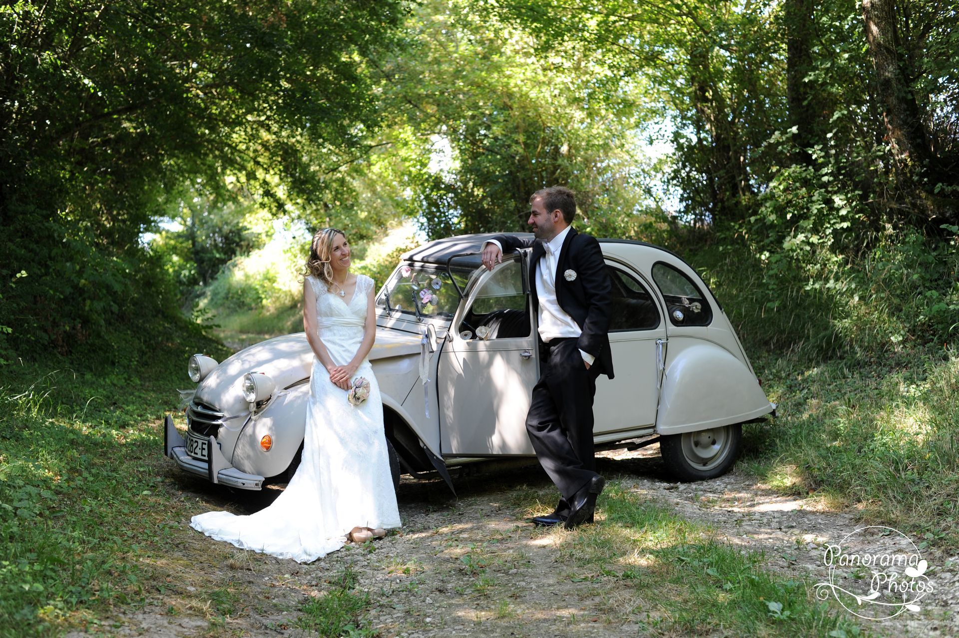 photo de mariage montrant des marié appuyer à une 2cv dans les bois