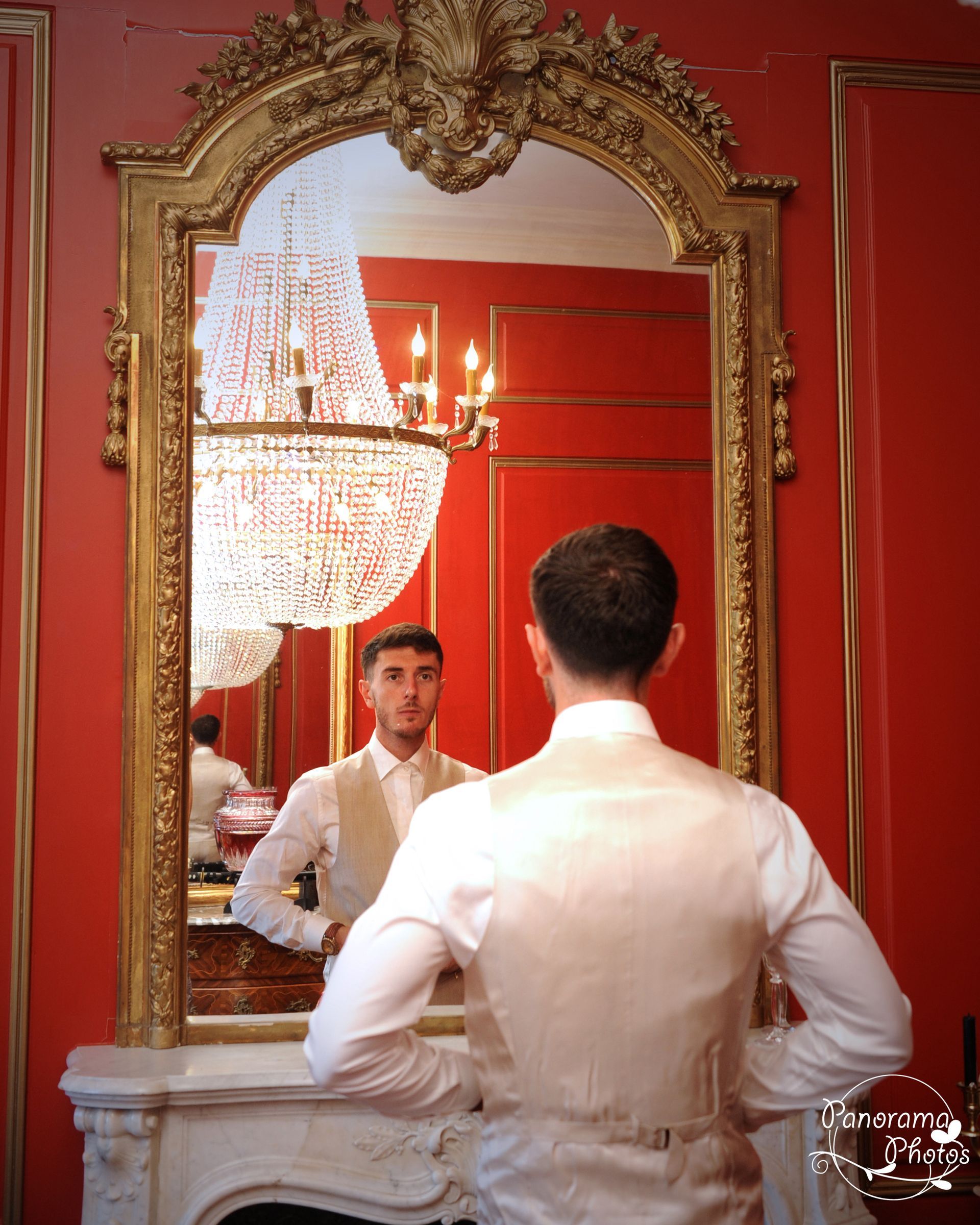 Photo d'un marié en train de s'habiller devant un miroir