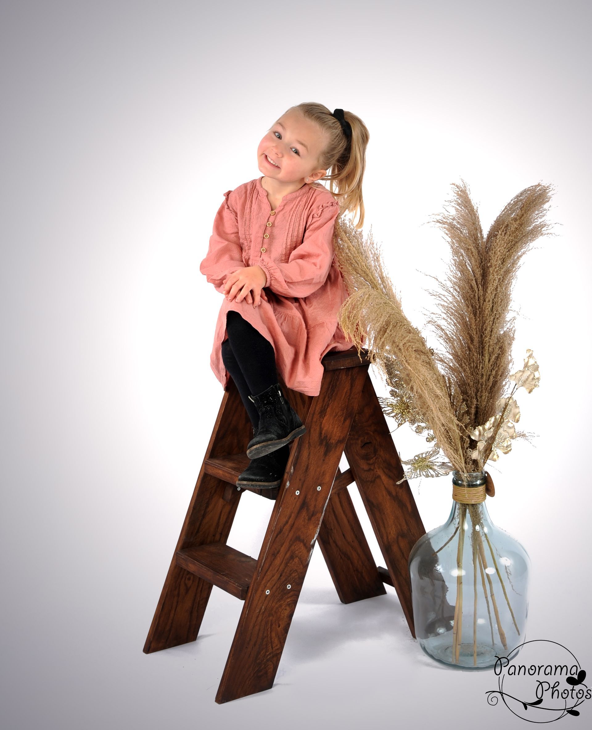 séance photo studio portrait petite fille assise sur un escabeau en bois