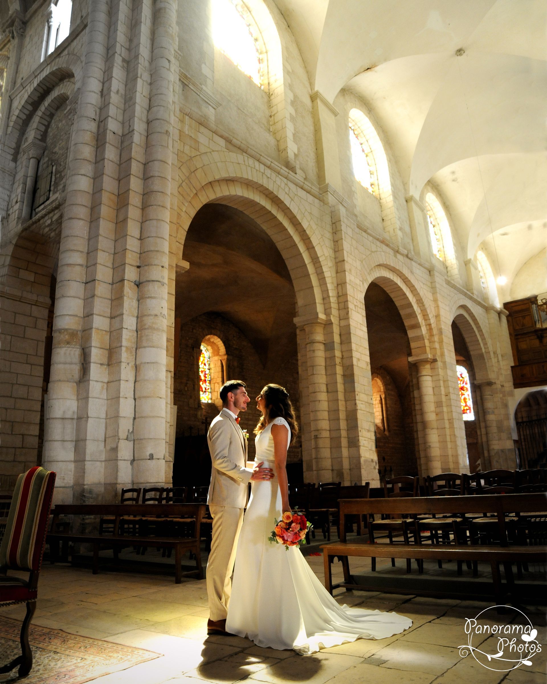 Photo d'un couple de mariés dans une église sous une lumière orangée