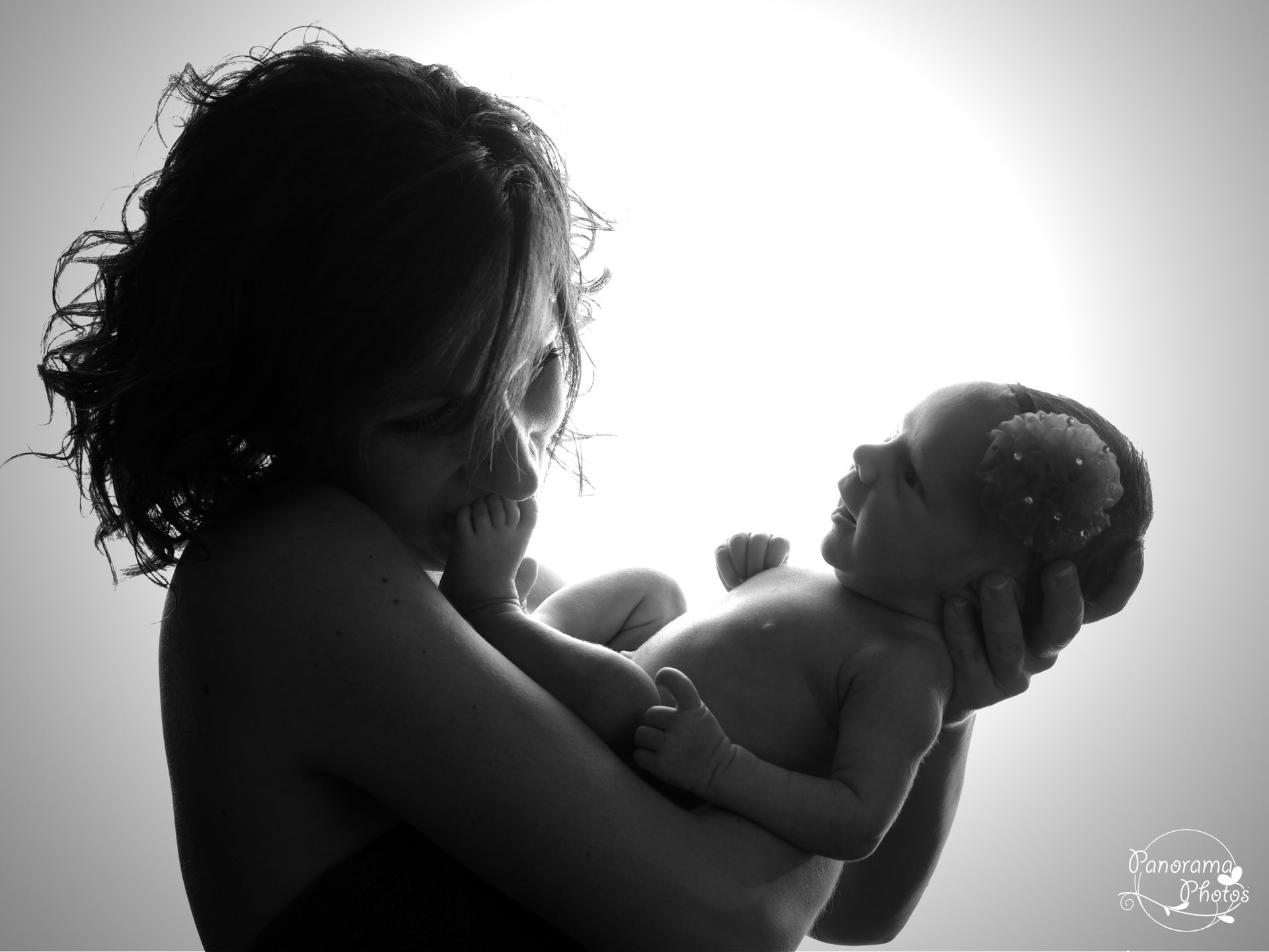 séance photo studio maman qui embrasse le pied de son bébé
