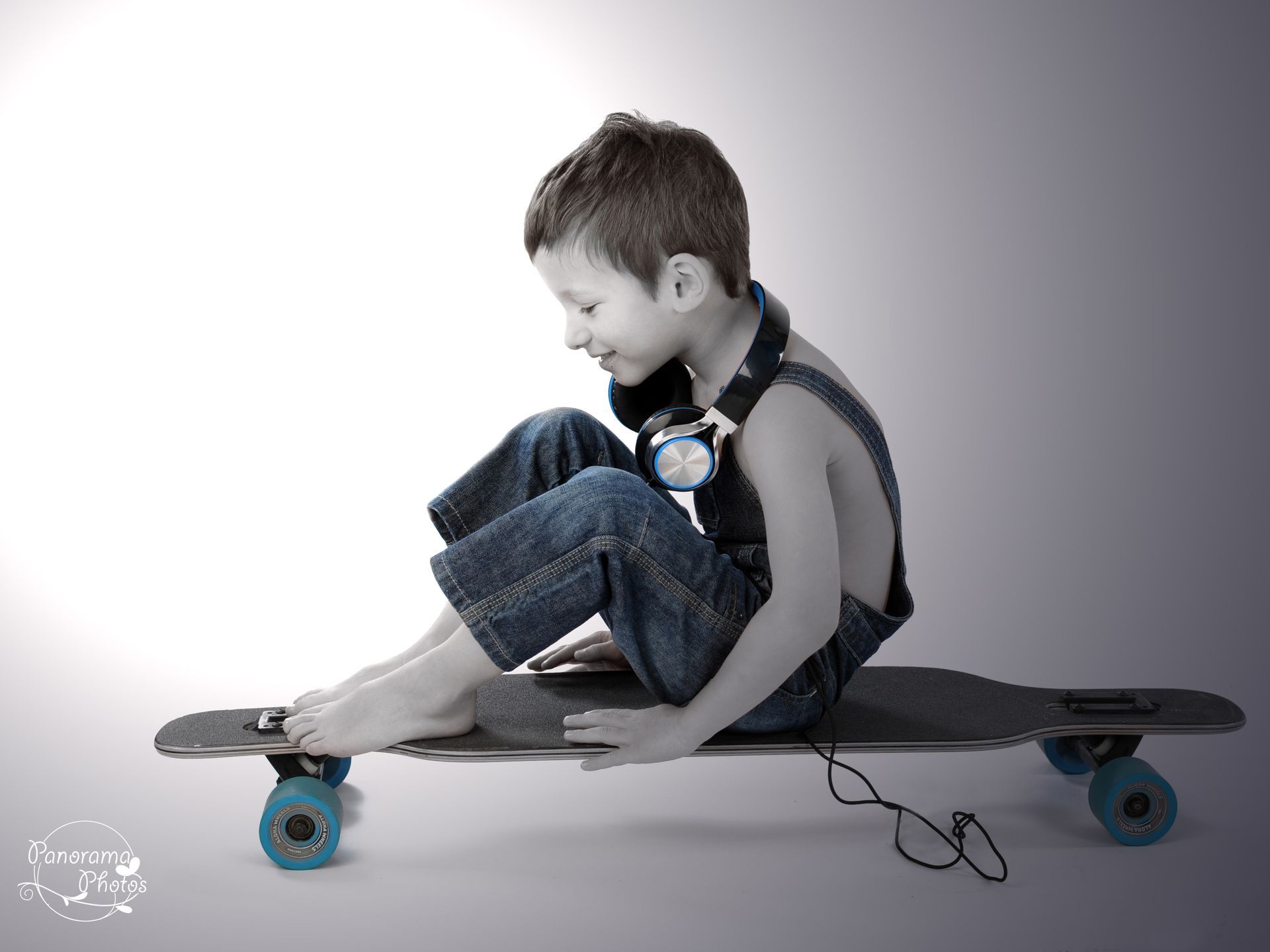 séance photo studio petit garçon en salopette sur skateboard