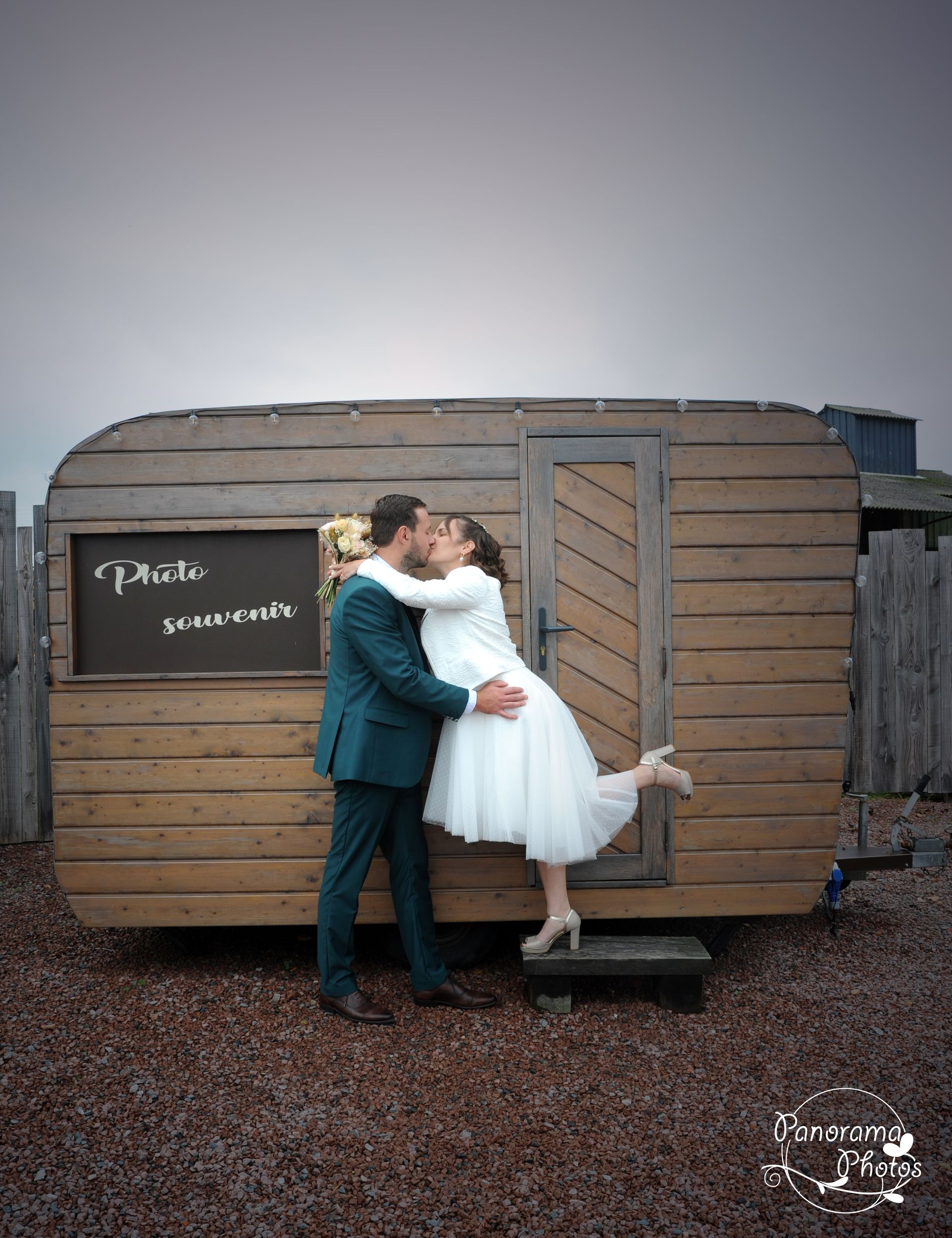 couple de marié s'embrassant devant une caravane restro