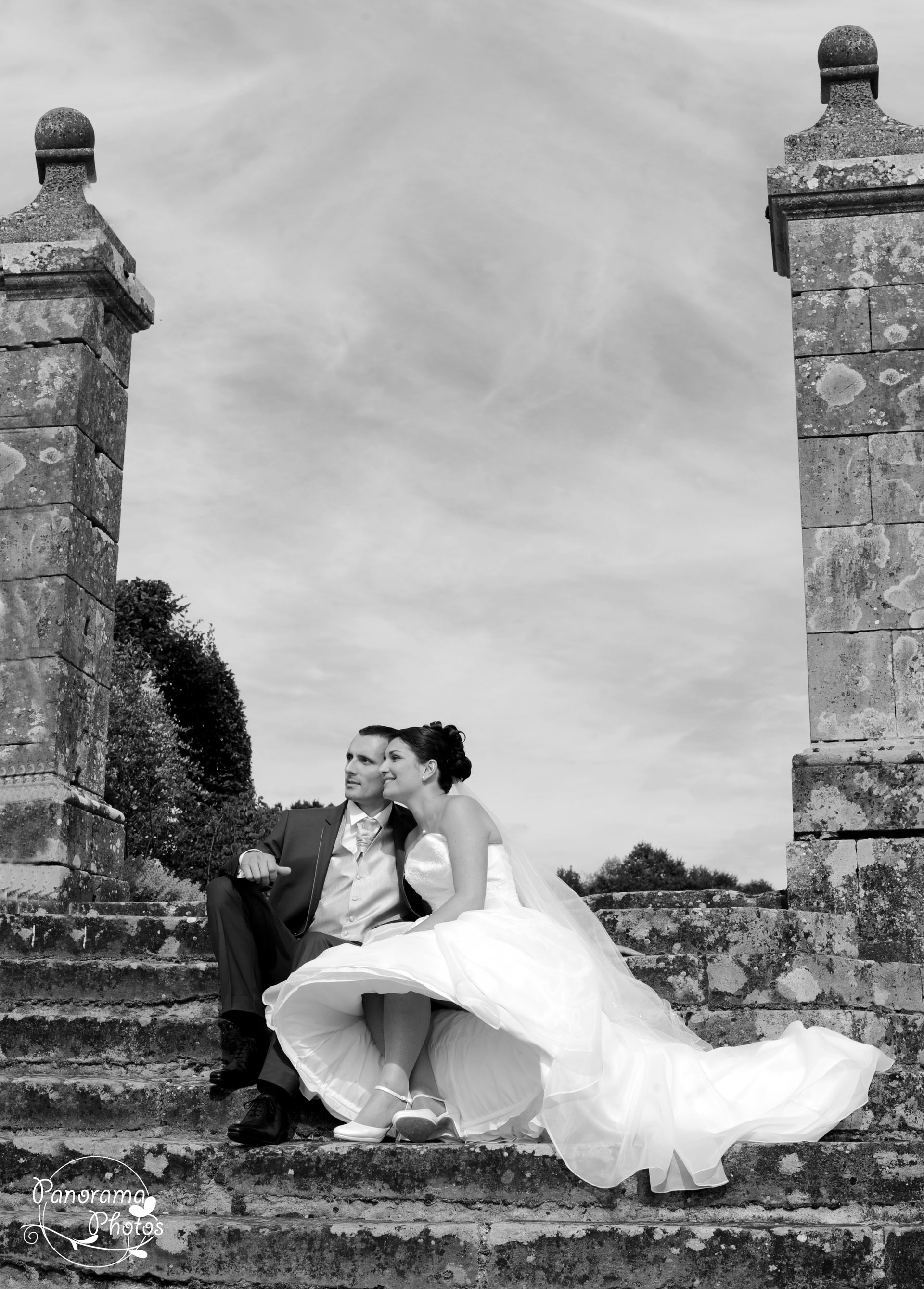 photo de mariage montrant un couple de mariés assis sur une marche