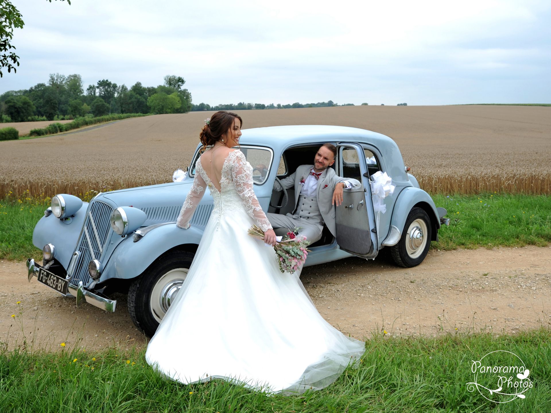 photo de mariage montrant des marié devant une voiture ancienne