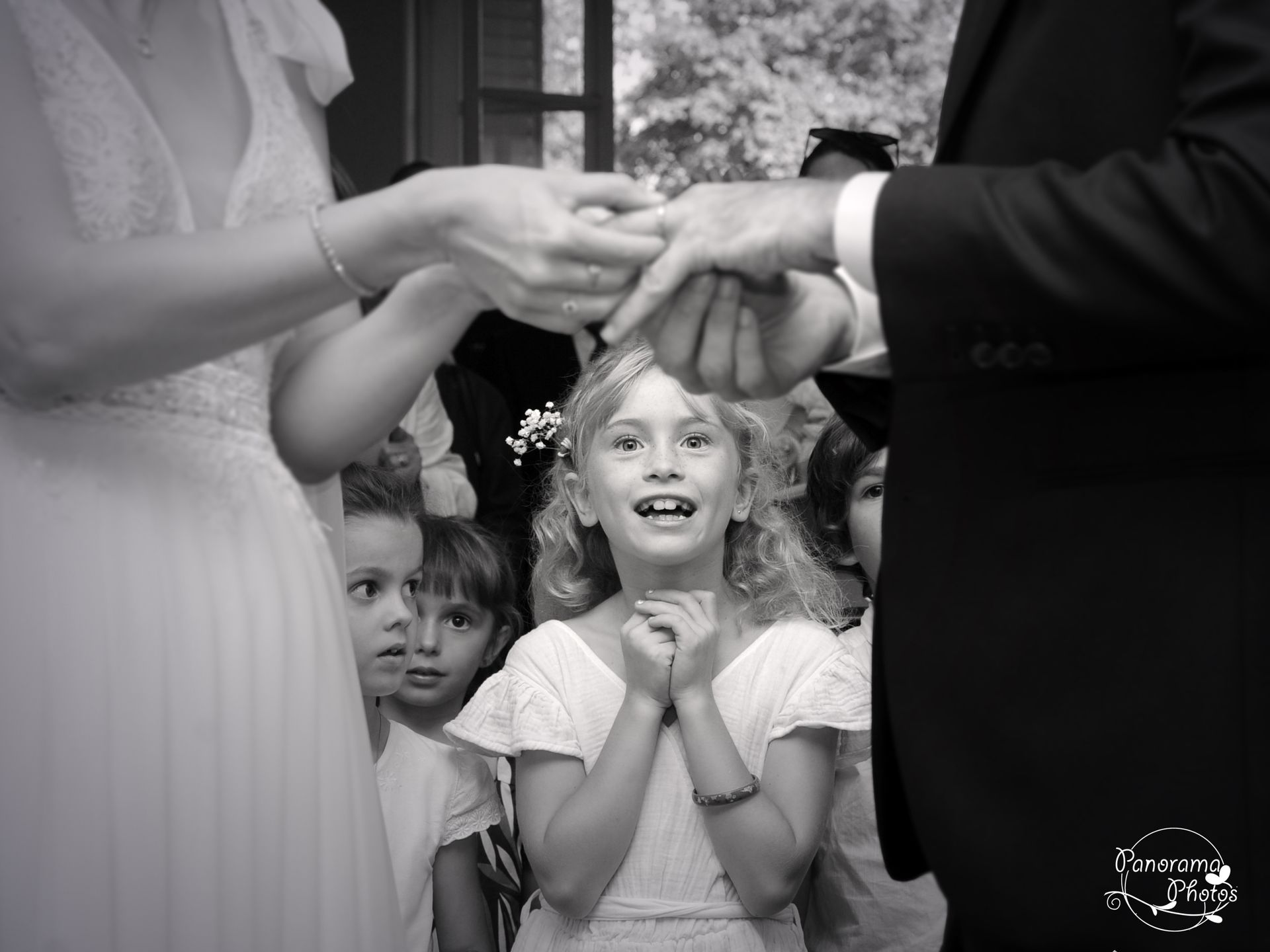 photo de mariage montrant une fillette souriant devant les mariés