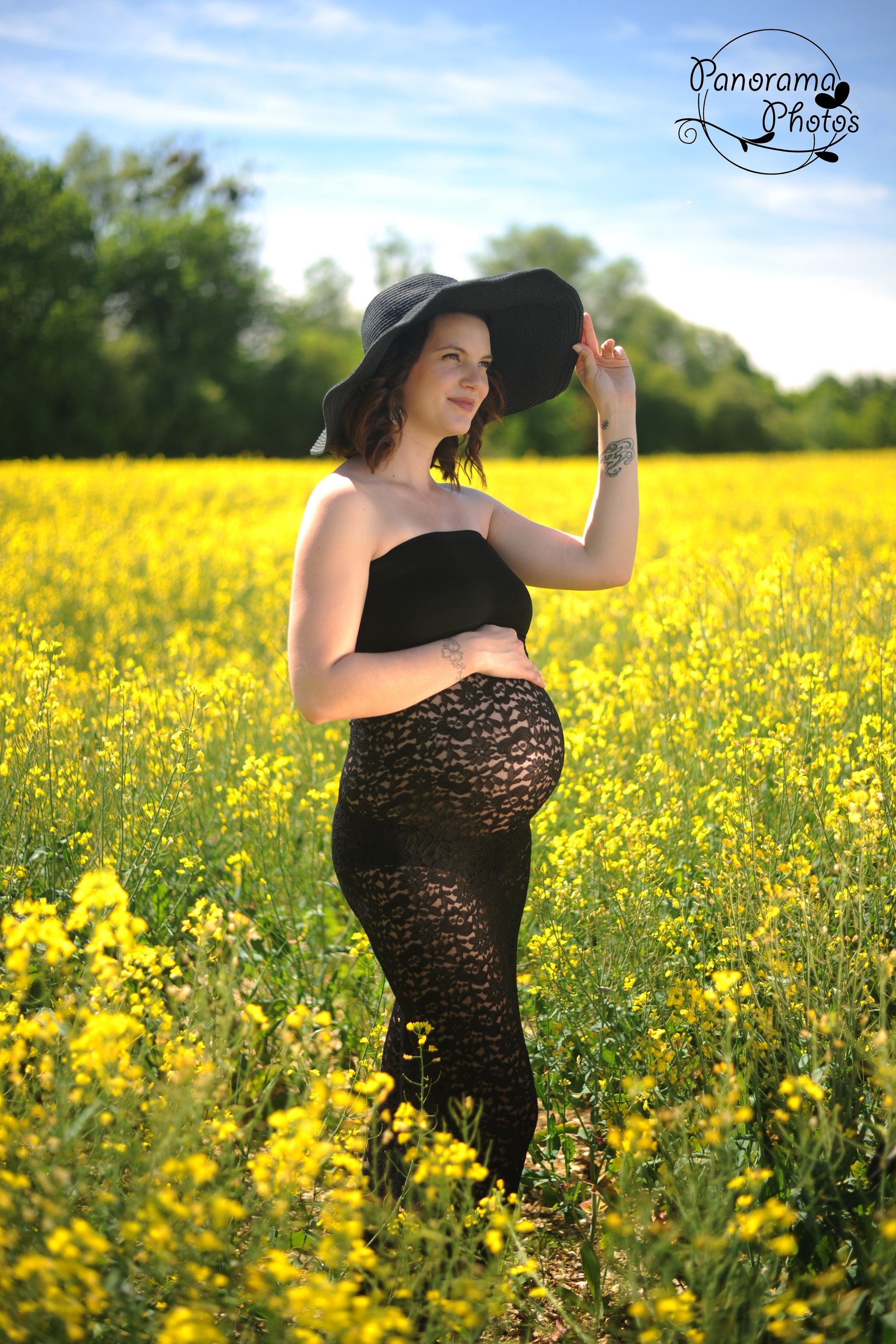 séance photo extérieure femme enceinte en robe dans dans un champs de colza