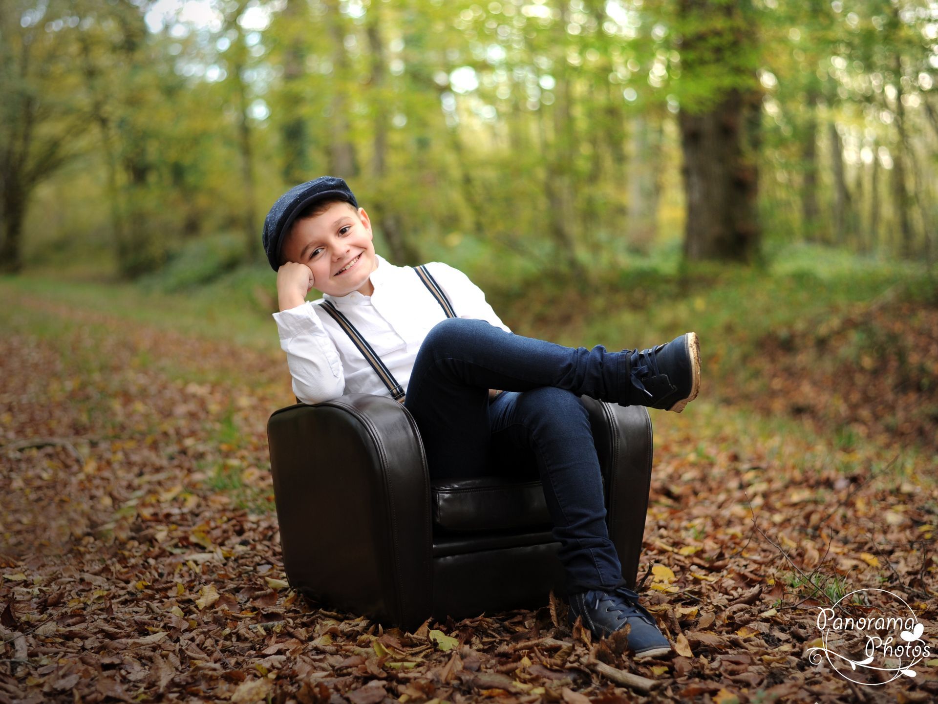 séance photo extérieure portrait garçon assis dans un fauteuil dans les bois