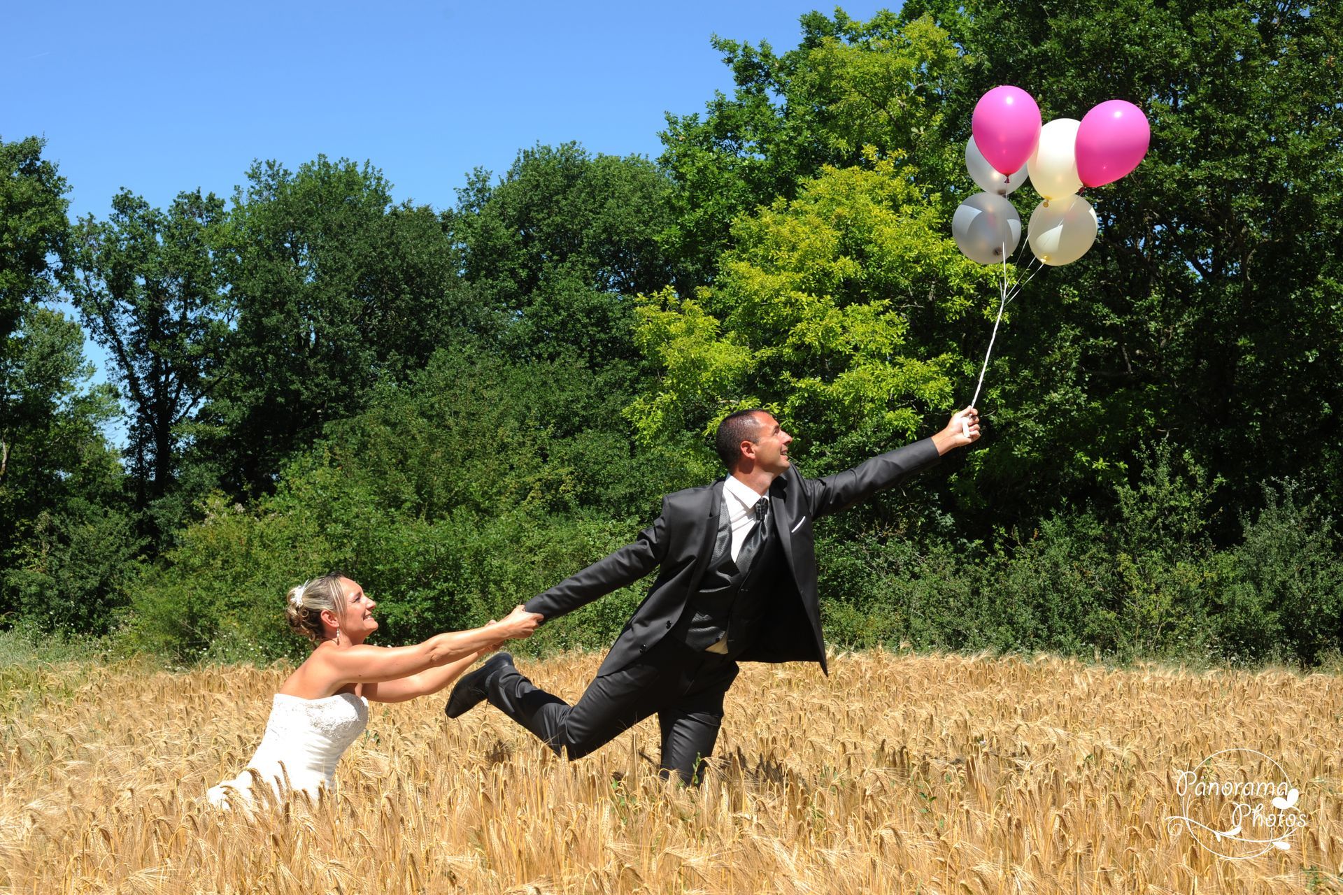 marié au milieu d'un champ de blé tenant un ballon