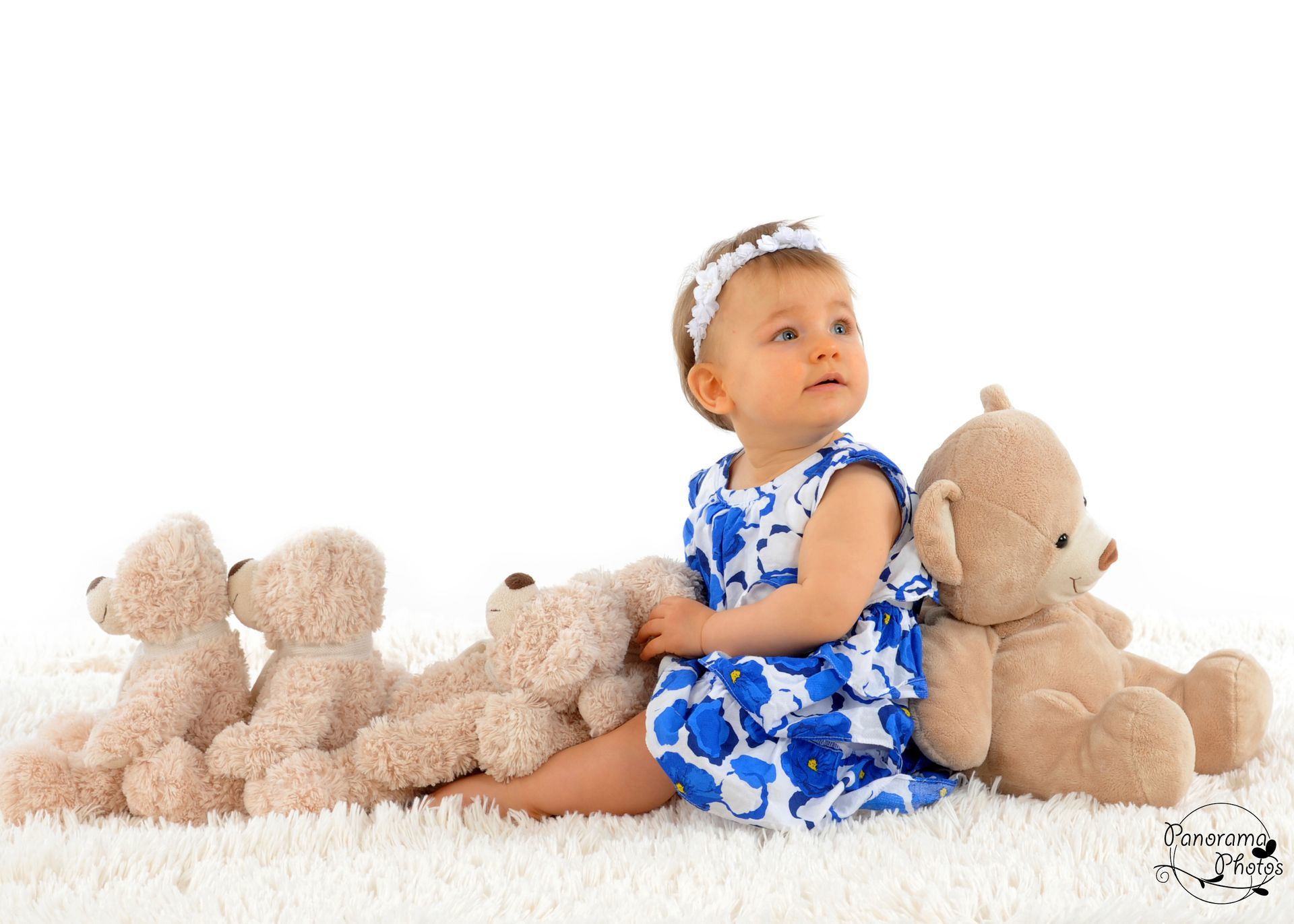 séance photo studio fillette assisse au milieu de peluches