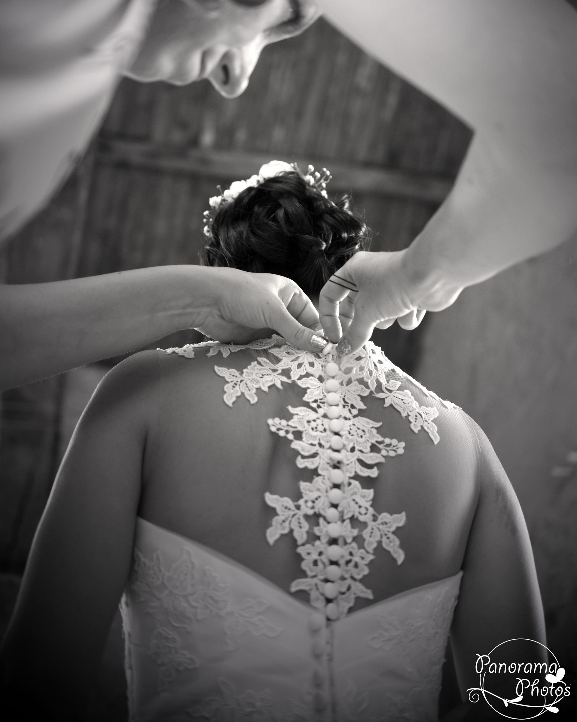 photo de mariage montrant une mariée qui attache sa robe