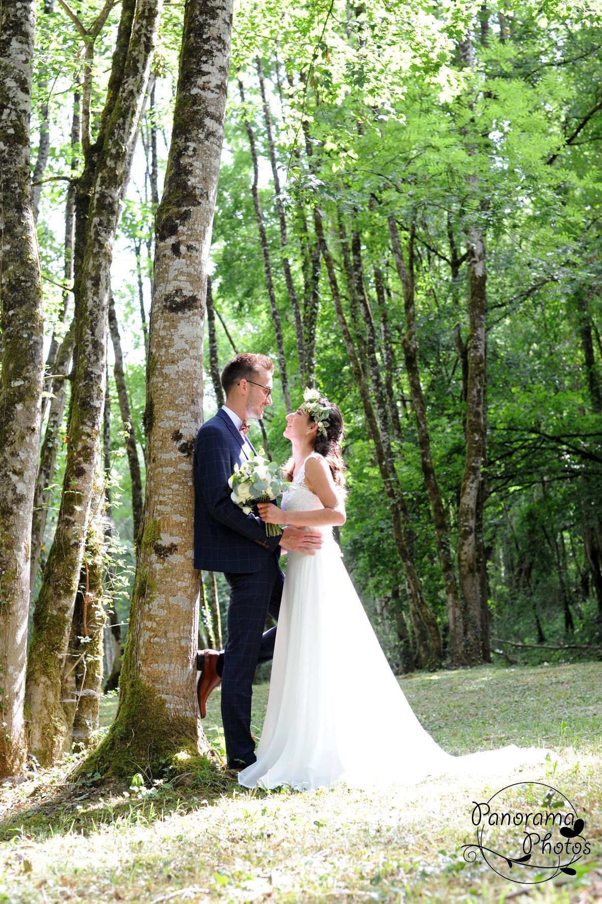 photo de mariage montrant un couple de mariés se regardant près d'un arbre