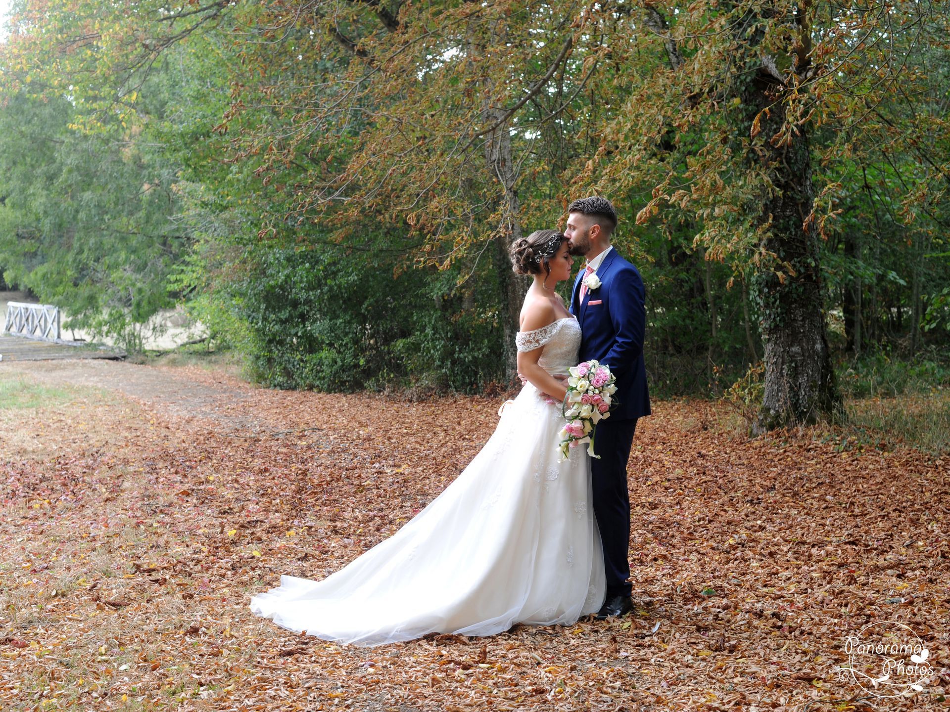 photo de mariage montrant des mariés sur un tapis de feuilles mortes