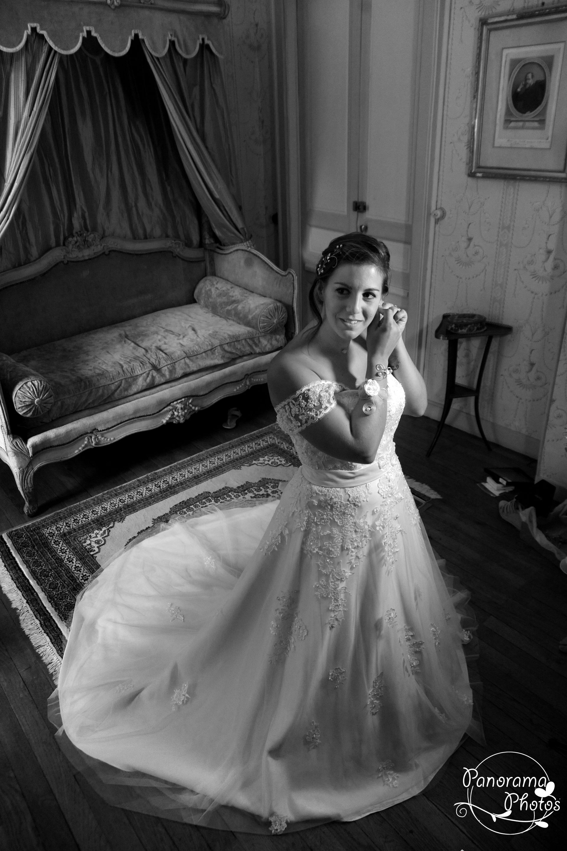 photo de mariage montrant une mariée qui attache sa boucle d'oreille