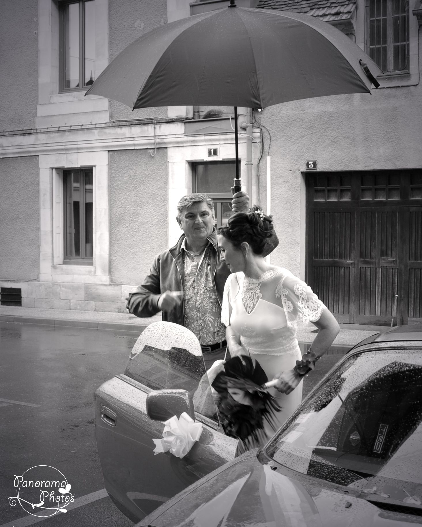 photo de mariage montrant une Marié qui sort de la voiture sous la pluie