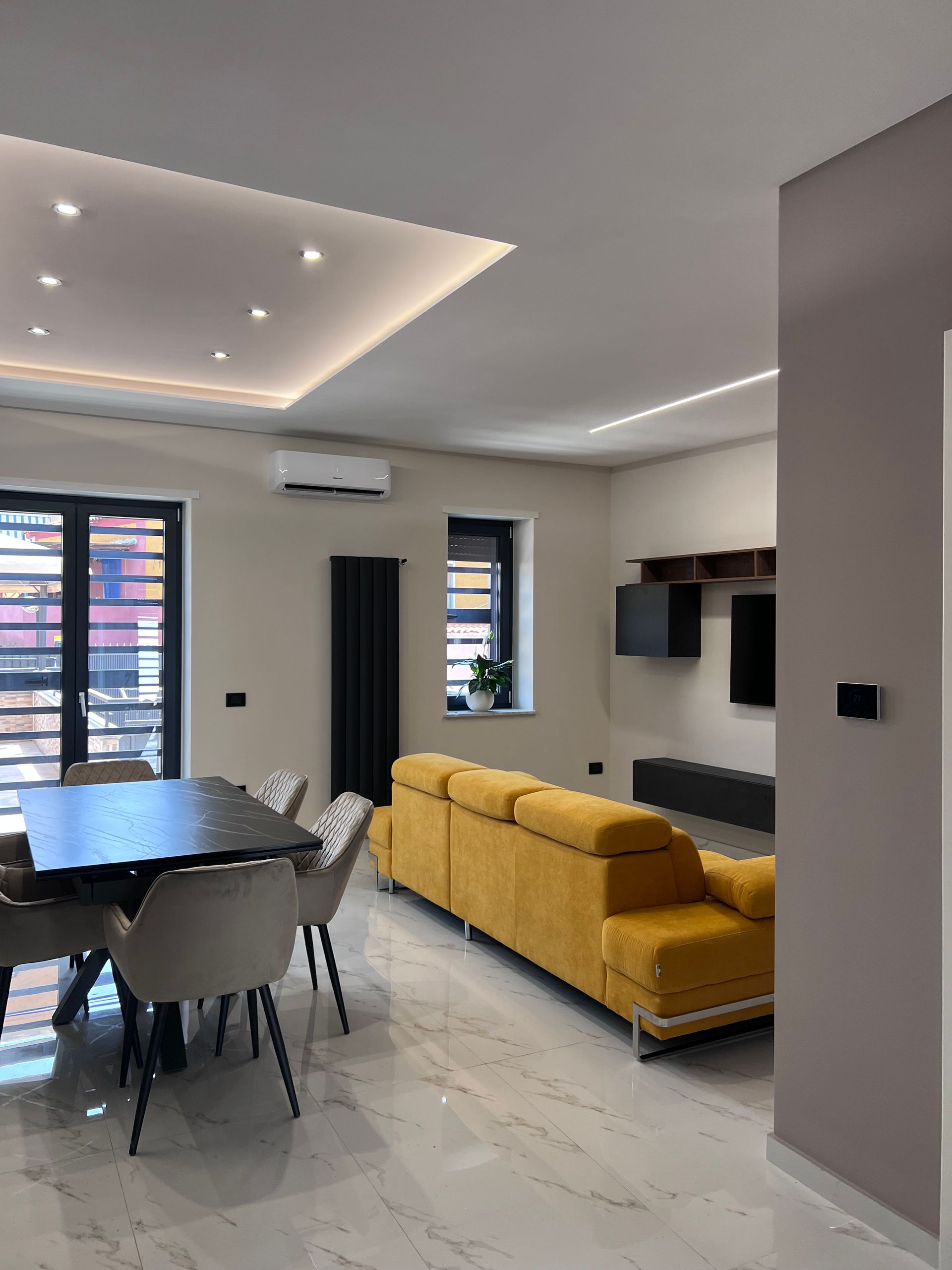 Illuminazione di una cucina moderna, con divano giallo.
