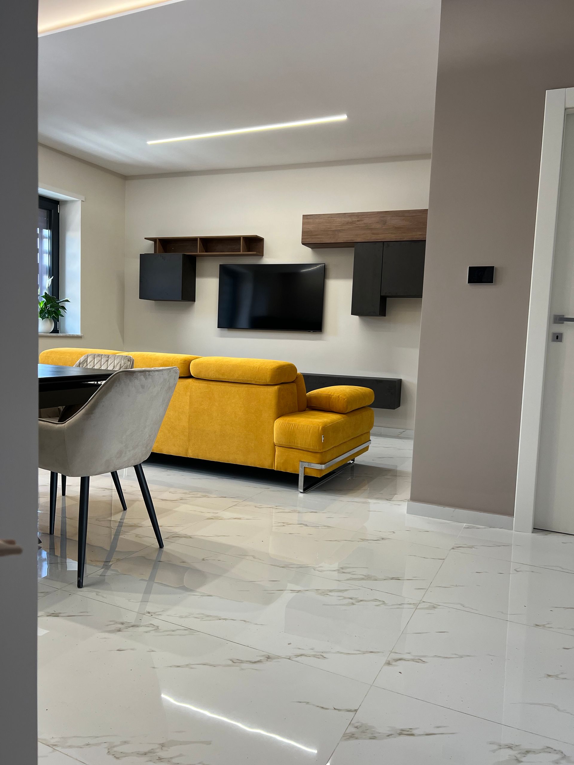 Ristrutturazione della parte elettrica di una sala, con televisione appesa al muro e del pavimento in ceramica.