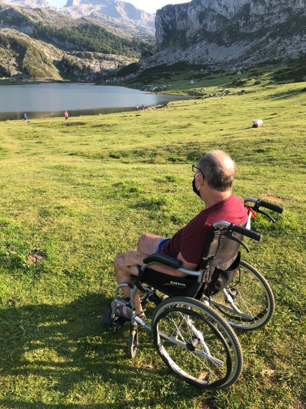 señor mirando un lago con montañas al fondo