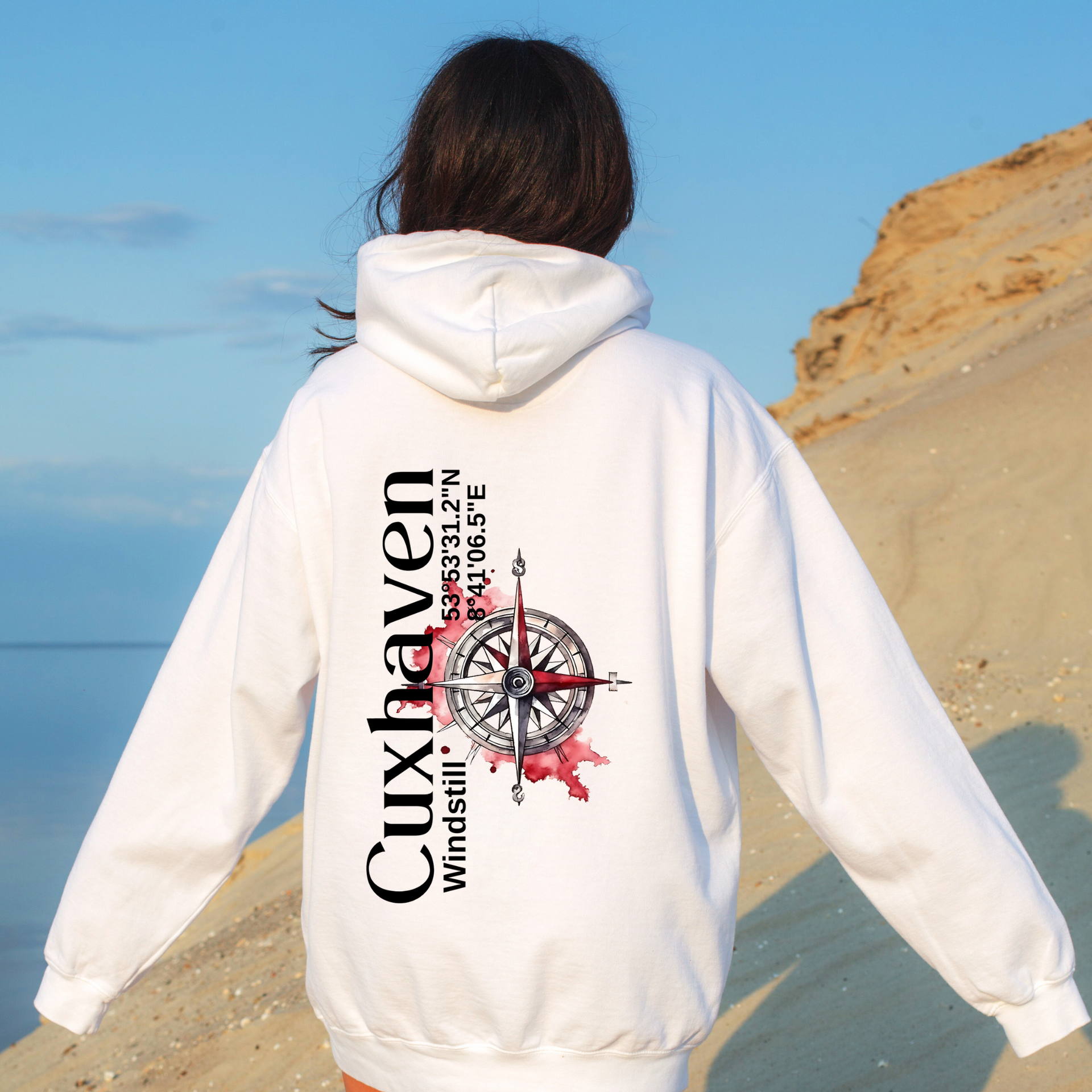 Hoodie mit Text und Koordinaten von Cuxhaven mit Bild von einem roten Kompass als Hintergrund