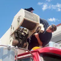 Technician mechanic repairing a hydraulic crane winch