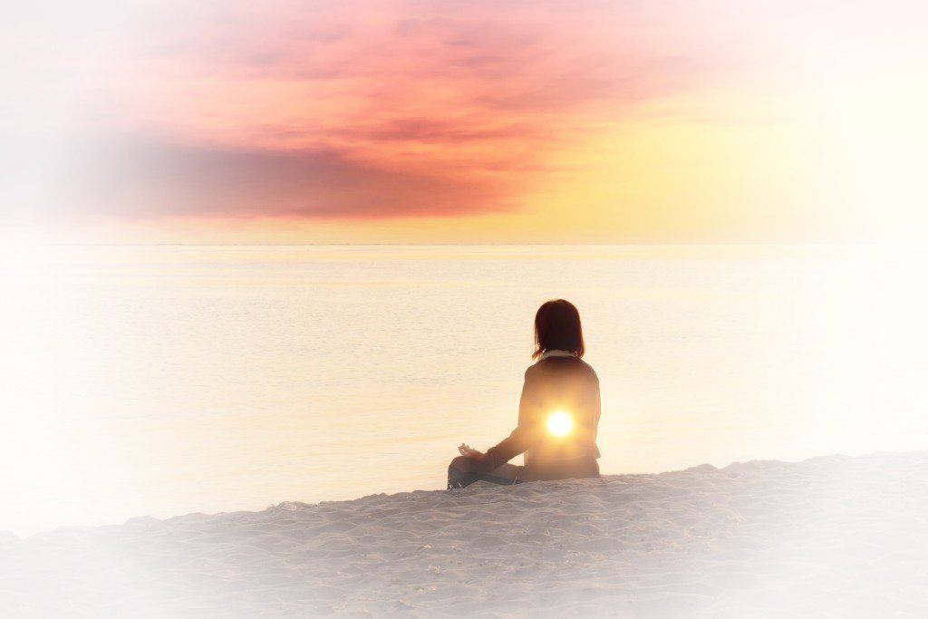 Meditierende Frau mit Blick aufs Meer als Intro zur mentalen Vorbereitung mit Hypnose